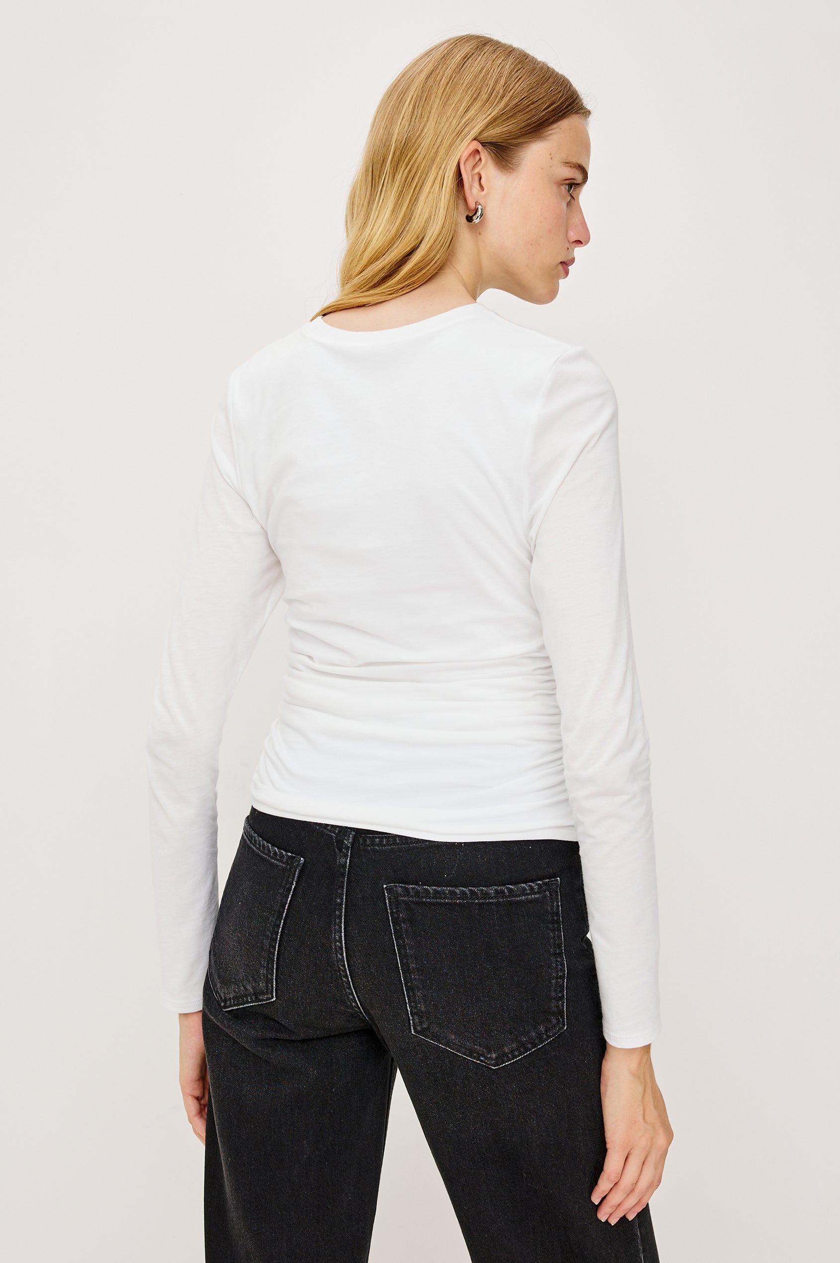 Melle Fitted Top in Organic Cotton With Crew Neckline, Side Shirring, and Long Sleeves in White Colorway - Upper Body Back View Featured on Model
