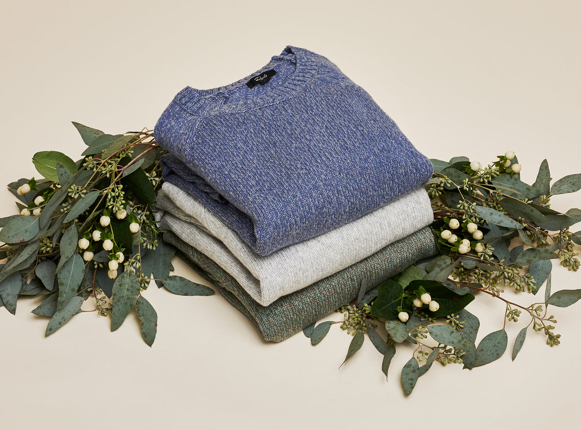 EDITORIAL IMAGE OF THREE SWEATERS FOLDED AND STACKED