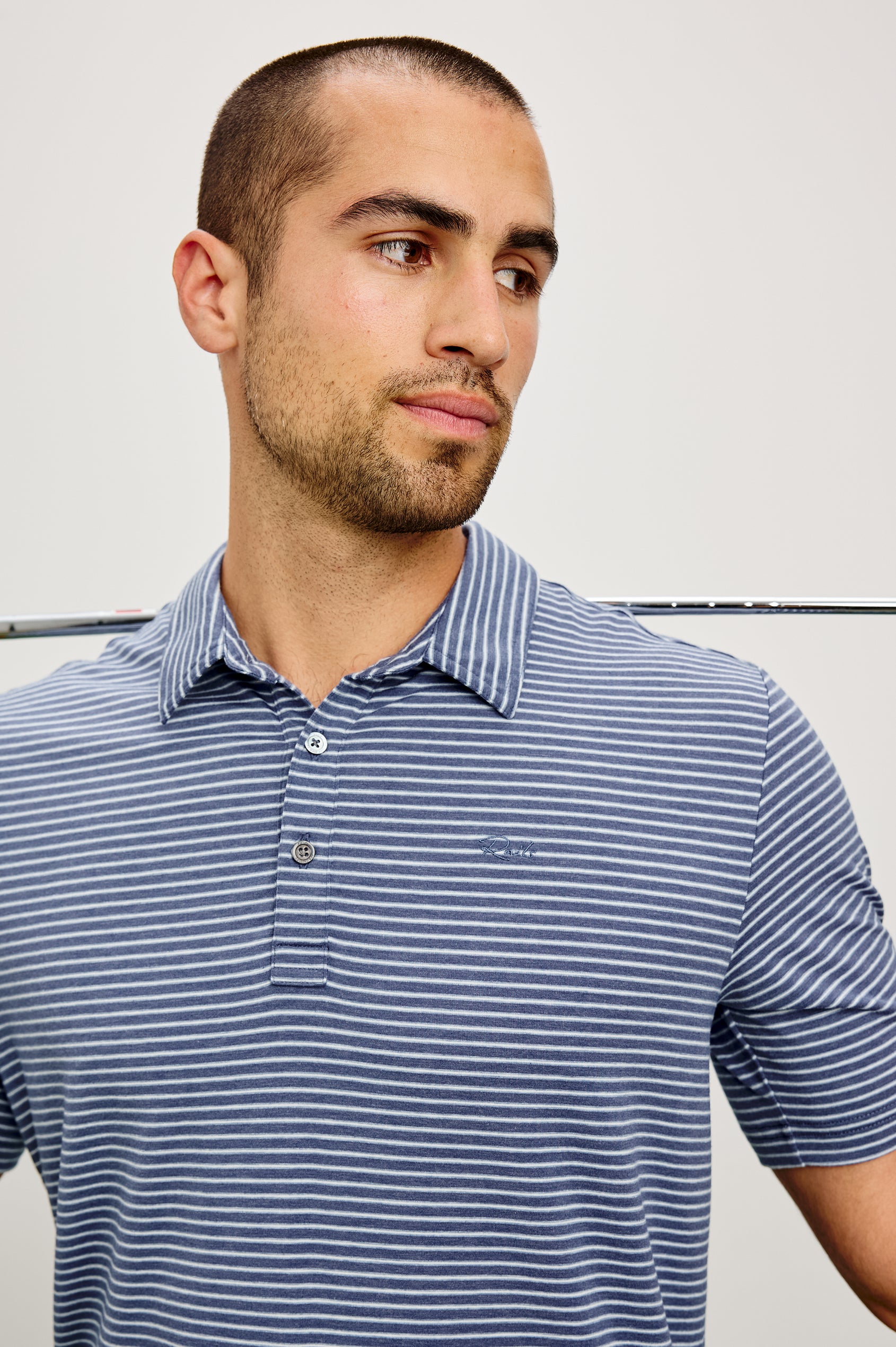 Merced Golf Polo in TENCEL™ Poly Blend With Collar, Quarter Placket, Short Sleeves, and Classic Fit in Navy Cosmo Stripe Colorway - Upper Body Front View Featured on Model