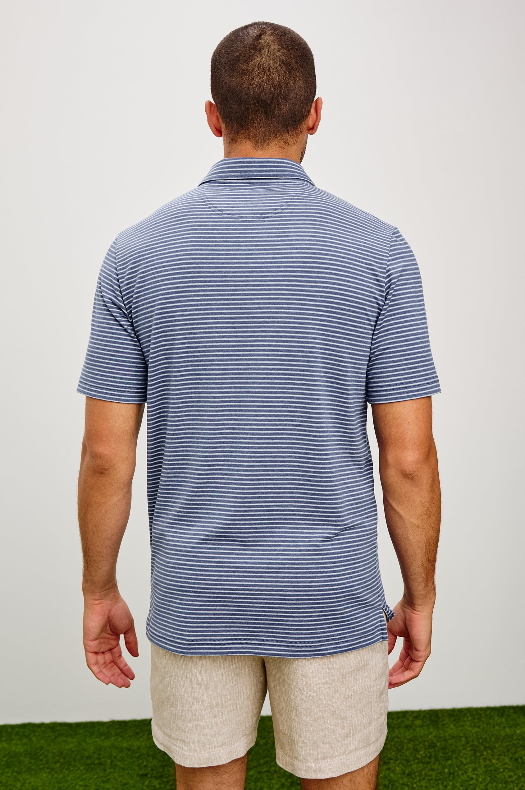 Merced Golf Polo in TENCEL™ Poly Blend With Collar, Quarter Placket, Short Sleeves, and Classic Fit in Navy Cosmo Stripe Colorway - Upper Body Back View Featured on Model