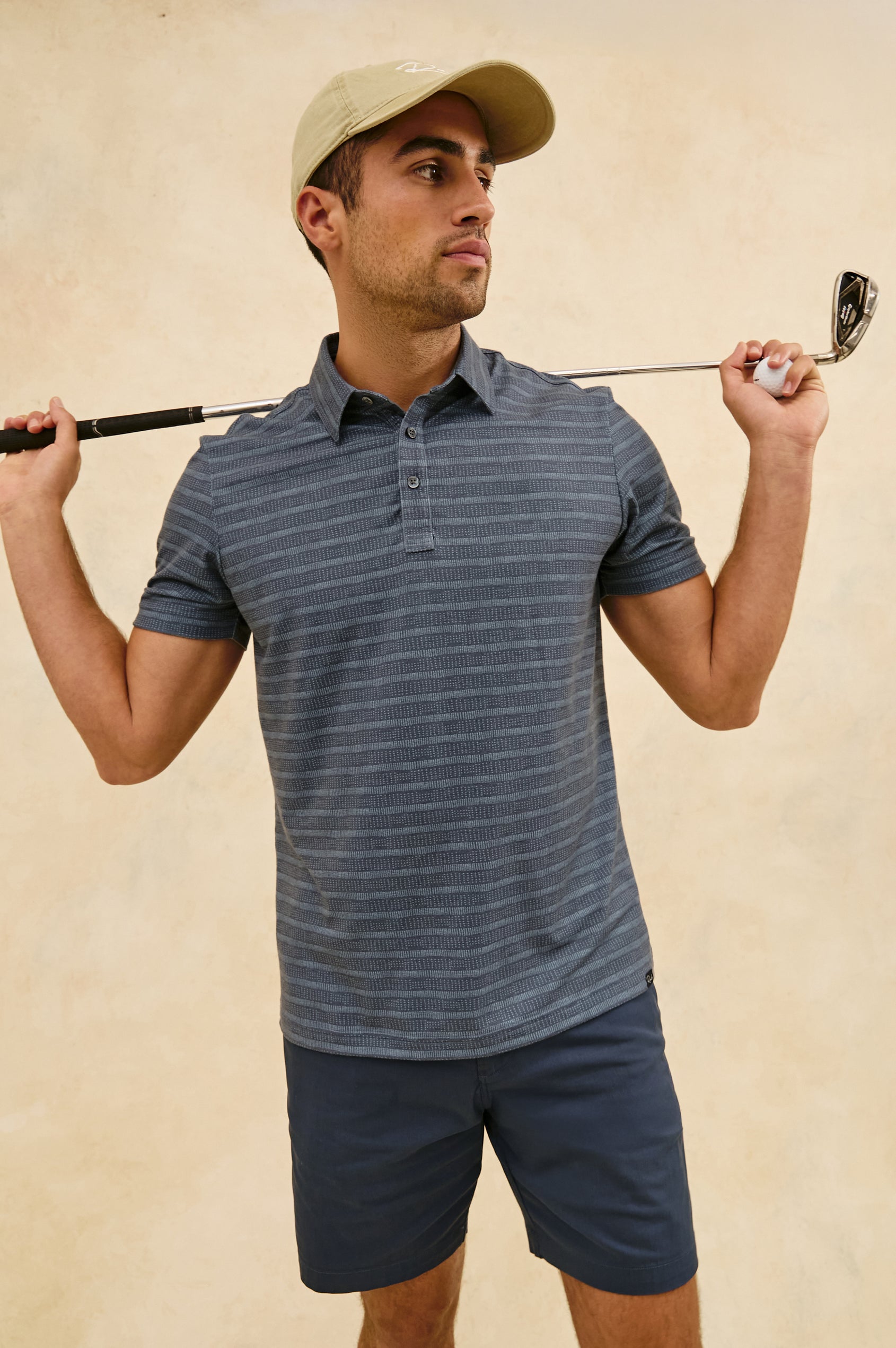 Merced short sleeve athletic Golf Polo with two button placket and collar in Sashiko Border Black - stylized front view on model with hat and golf club