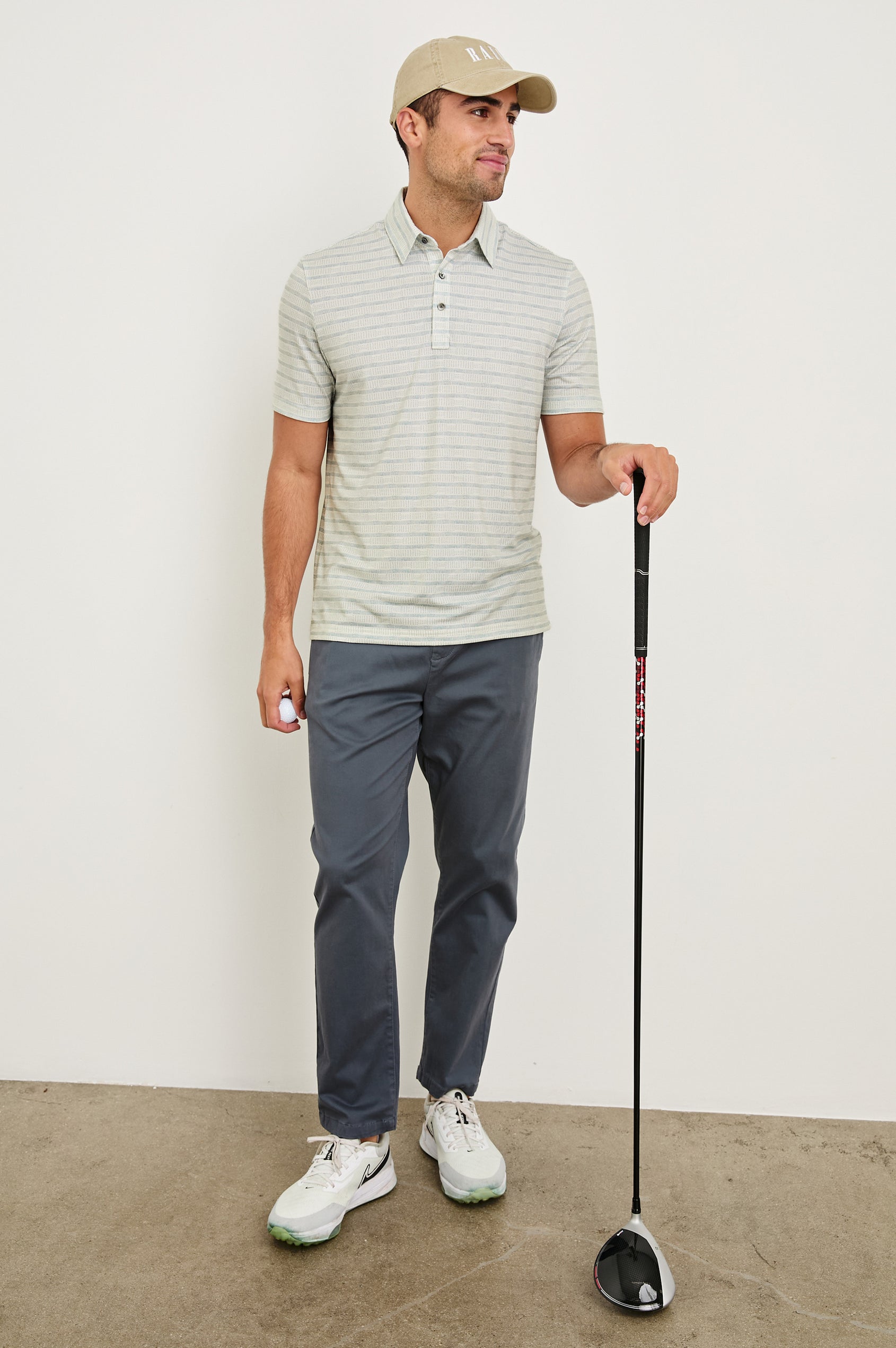Merced short sleeve athletic Golf Polo with two button placket and collar in Sashiko Border White - full body front view on model, holding golf club and ball