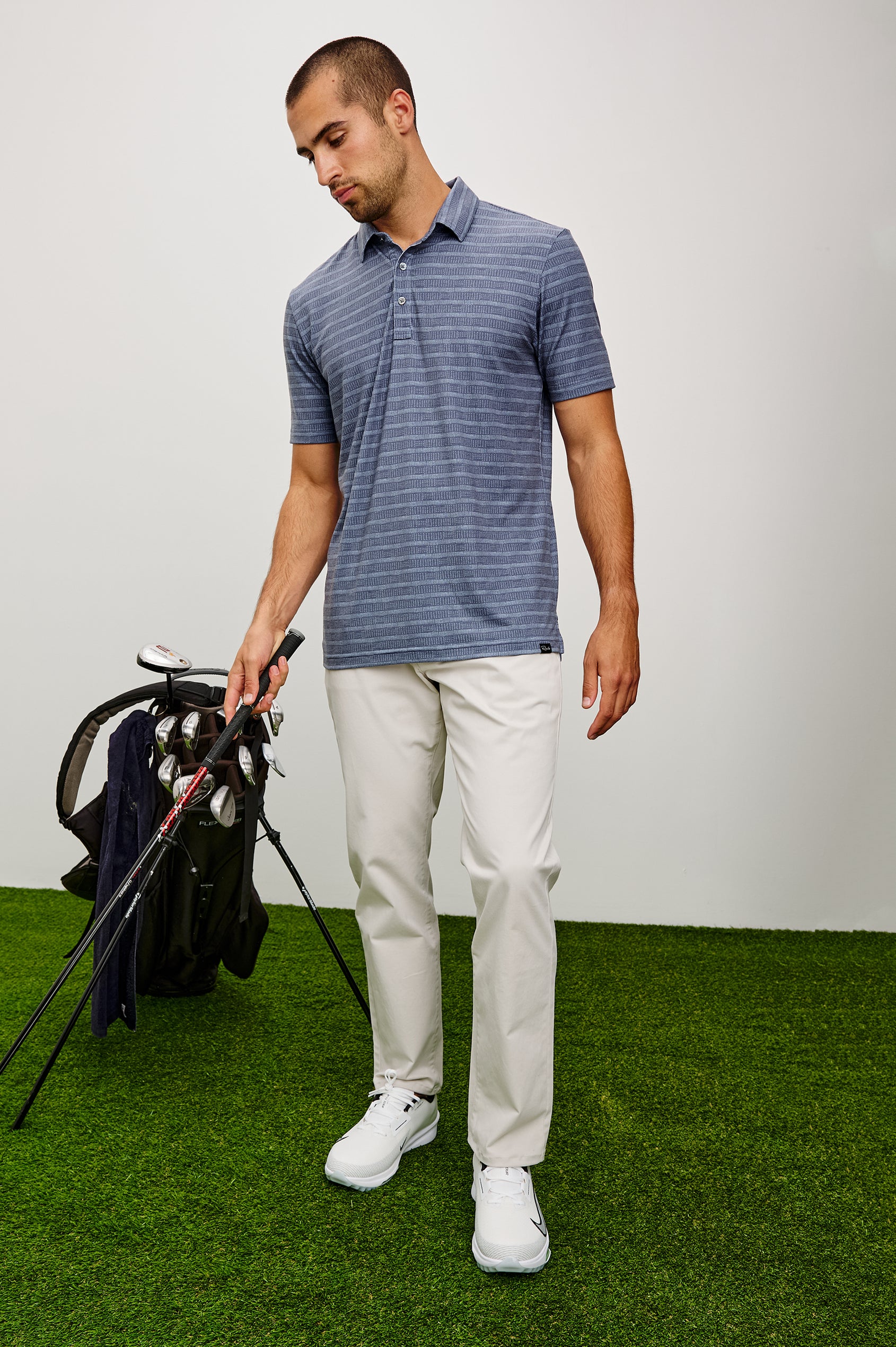 Merced Golf Polo in TENCEL™ Poly Blend With Collar, Quarter Placket, Short Sleeves, and Classic Fit in Hibiscus Mirage Stripe Colorway - Full Body Front View Featured on Model