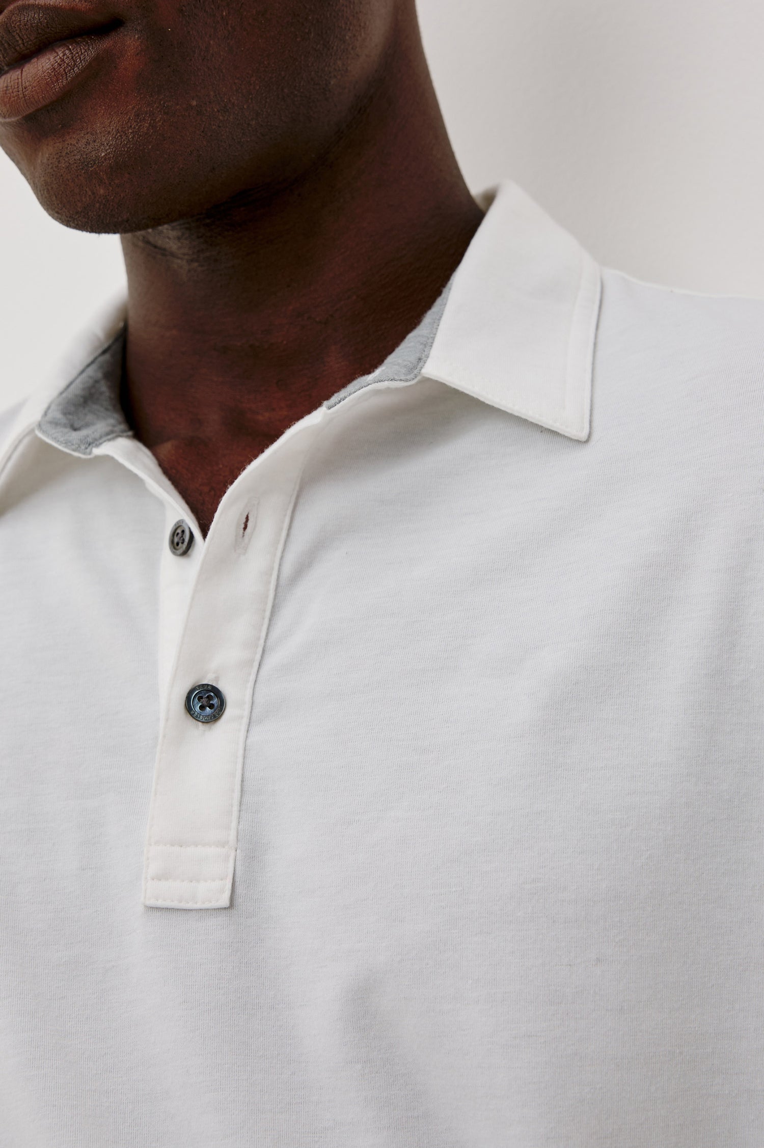 Merced Golf Polo in TENCEL™-Poly Stretch Blend With Moisture-Wicking Properties, Collar, Quarter-Placket, and Short Sleeves in White Colorway - Upper Body Close Up View Featured on Model