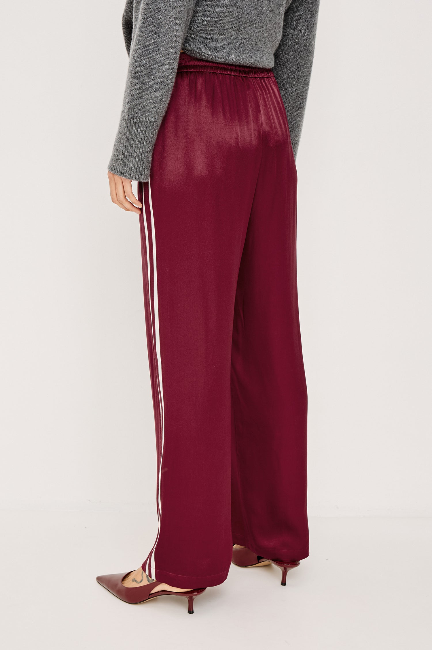 Merida Pant in Satin Back Crepe With Elastic Waistband, Side Pockets, and Wide Legs With Double Side Stripes in Garnet Colorway - Lower Body Back View Featured on Model