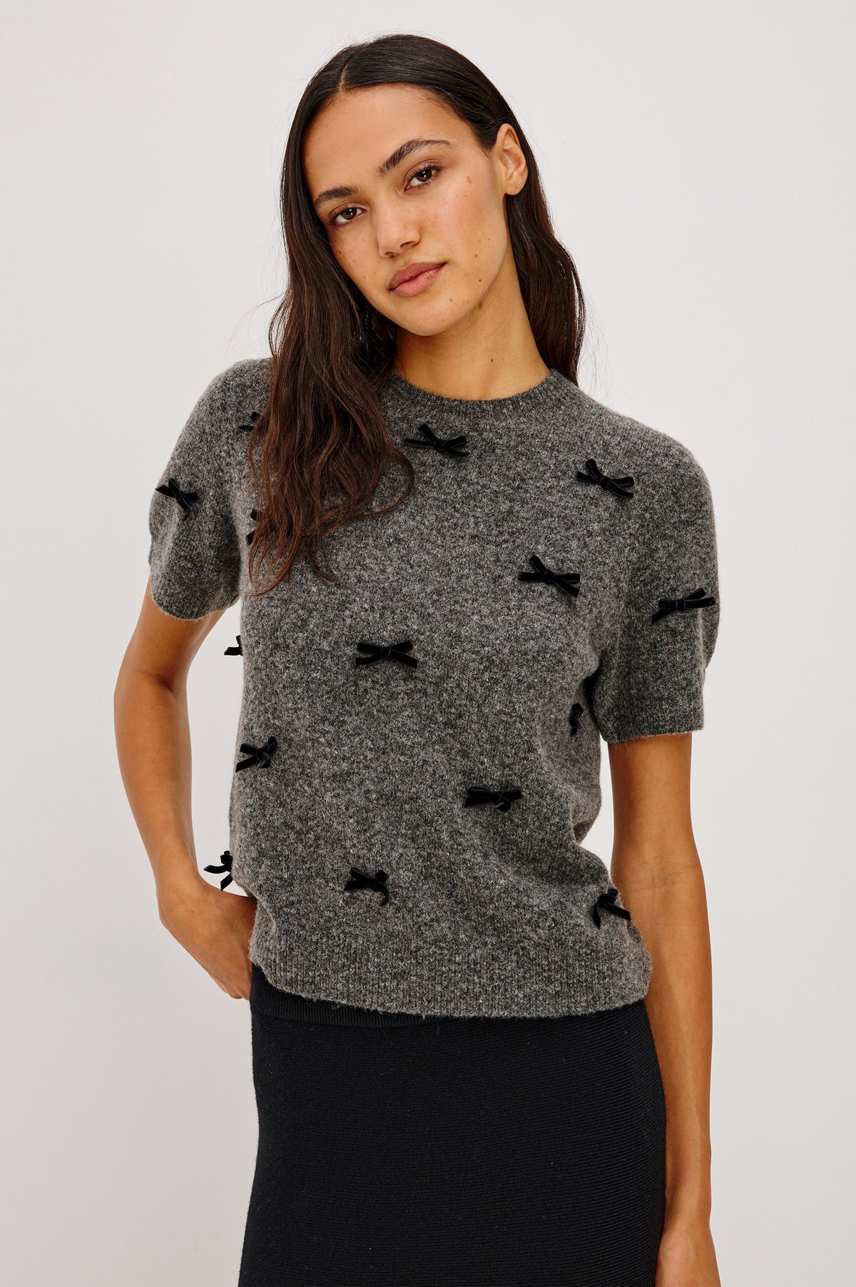 Michele Sweater in Wool Blend With an Off-The-Shoulder Neckline and Bow Applique in Charcoal Colorway - Front Crop View Featured on Model.
