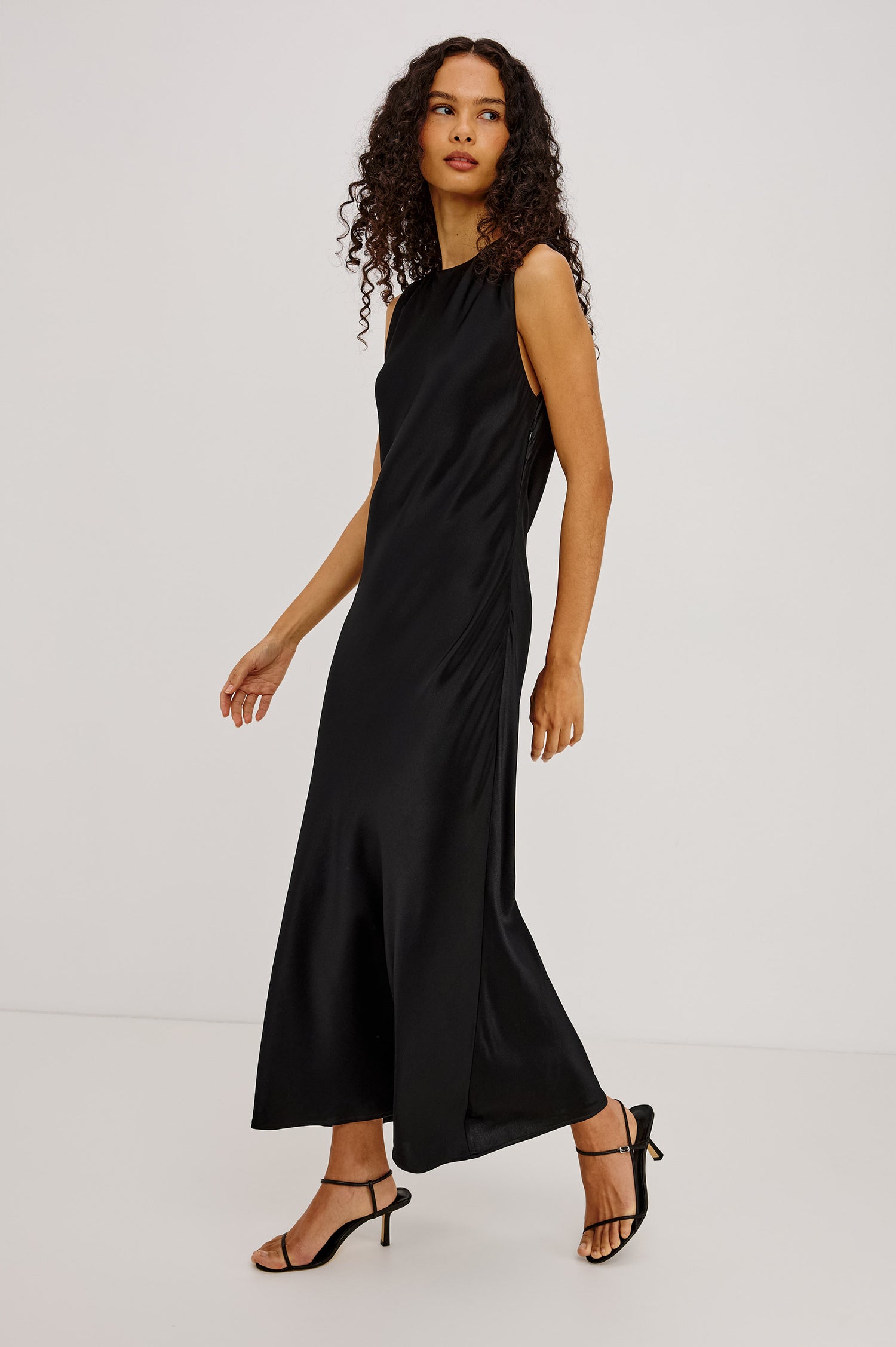 Mira Maxi Dress Bias Cut in Satin-Back Crepe With Crew Neckline, Pleated Shoulders, Side Zipper, and Keyhole Back With Button-Loop Closure in Black Colorway - Full Body Side View Featured on Model