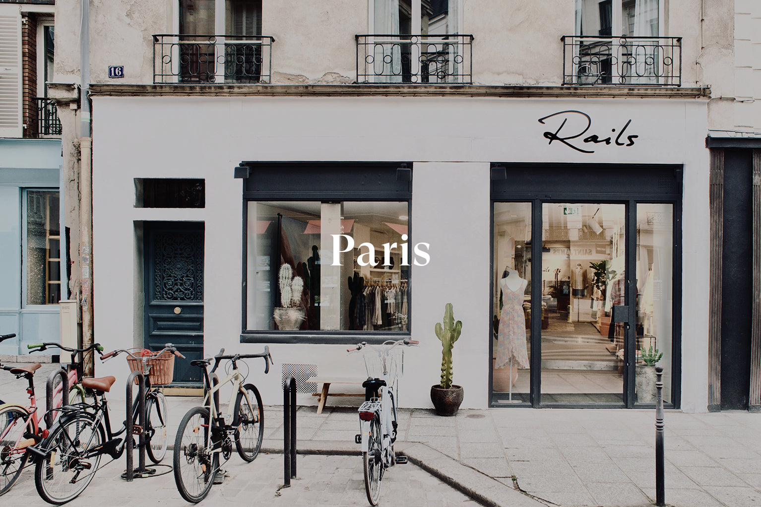 OUTSIDE OF PARIS STORE SHOWING THE FRONT ENTRANCE (LARGE GLASS DOOR) AND LARGE FRONT WINDOW