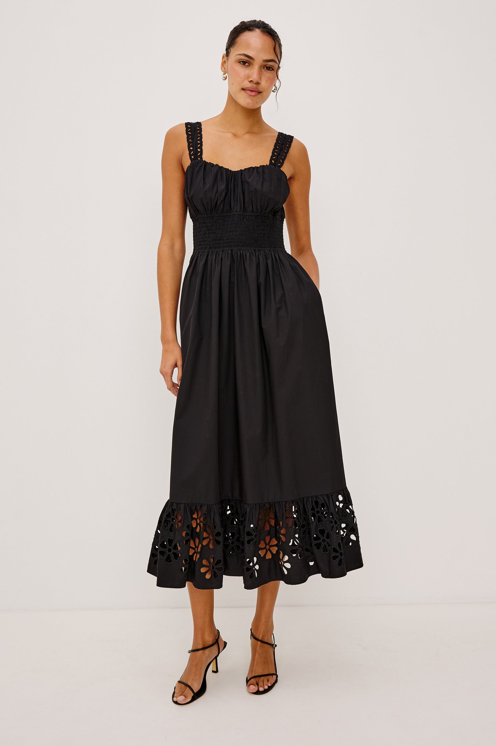 Moira Midi Dress in Cotton Poplin With Wide Embroidered Shoulder Straps, Soft Sweetheart Neckline, Smocked Empire Waist, Fully Lined Skirt With Floral Cutwork at Hem in Black Colorway - Full Body Front View Featured on Model