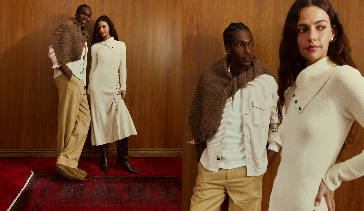 Three models pose in a warm-toned indoor setting with wood-paneled walls and a red rug. The outfits feature cream knit turtleneck dresses, beige trousers, white shirts, and brown textured knit shawls.