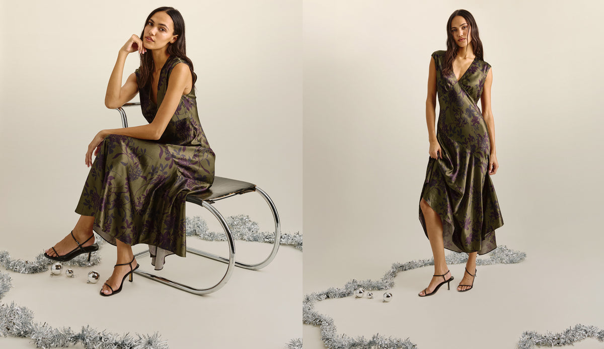 A woman modeling a sleeveless dark olive green midi dress with a subtle floral pattern, shown in two studio poses against a light beige background with decorative silver tinsel.
