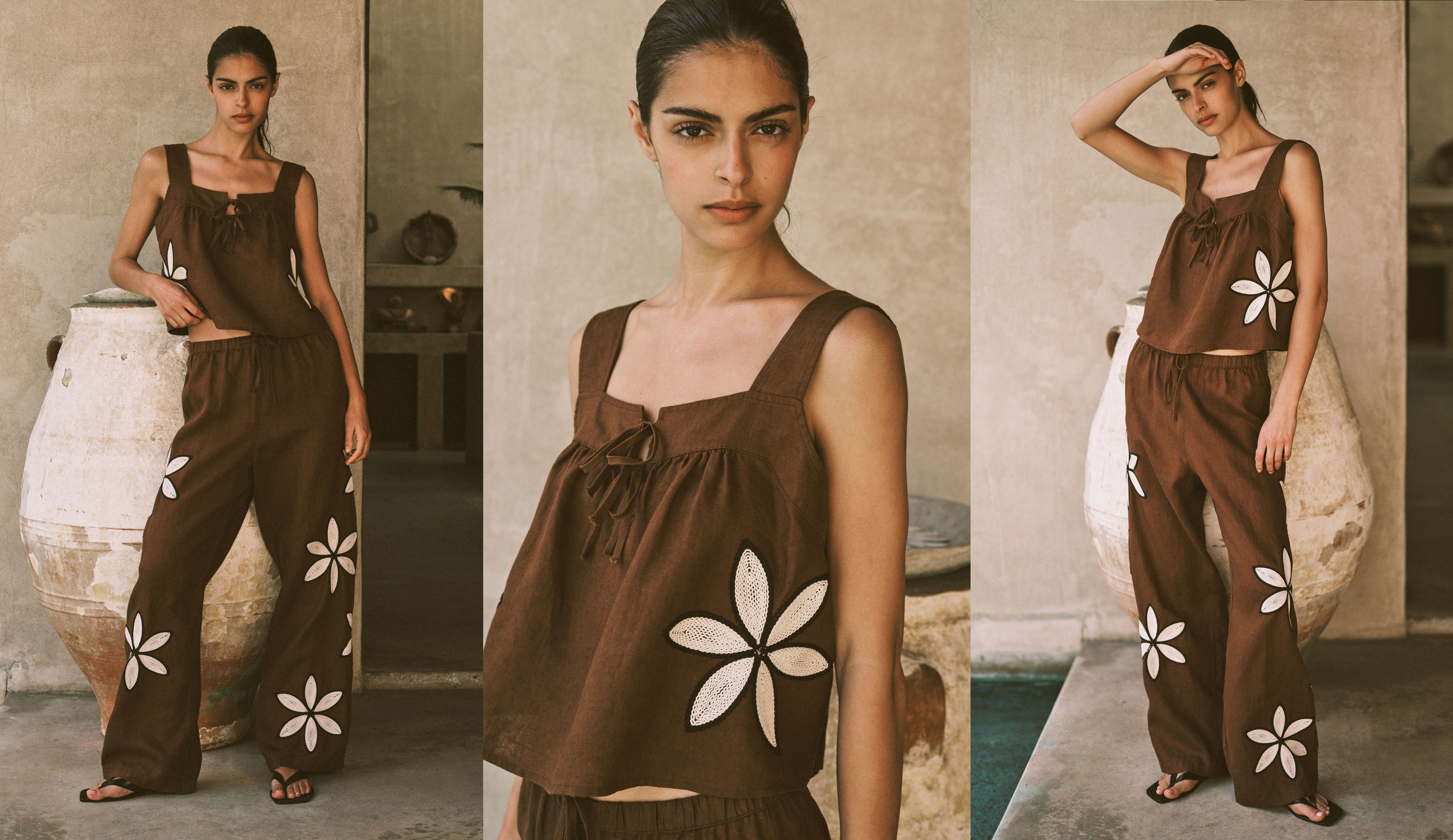 Woman wearing a brown outfit with white floral patterns in an outdoor setting.