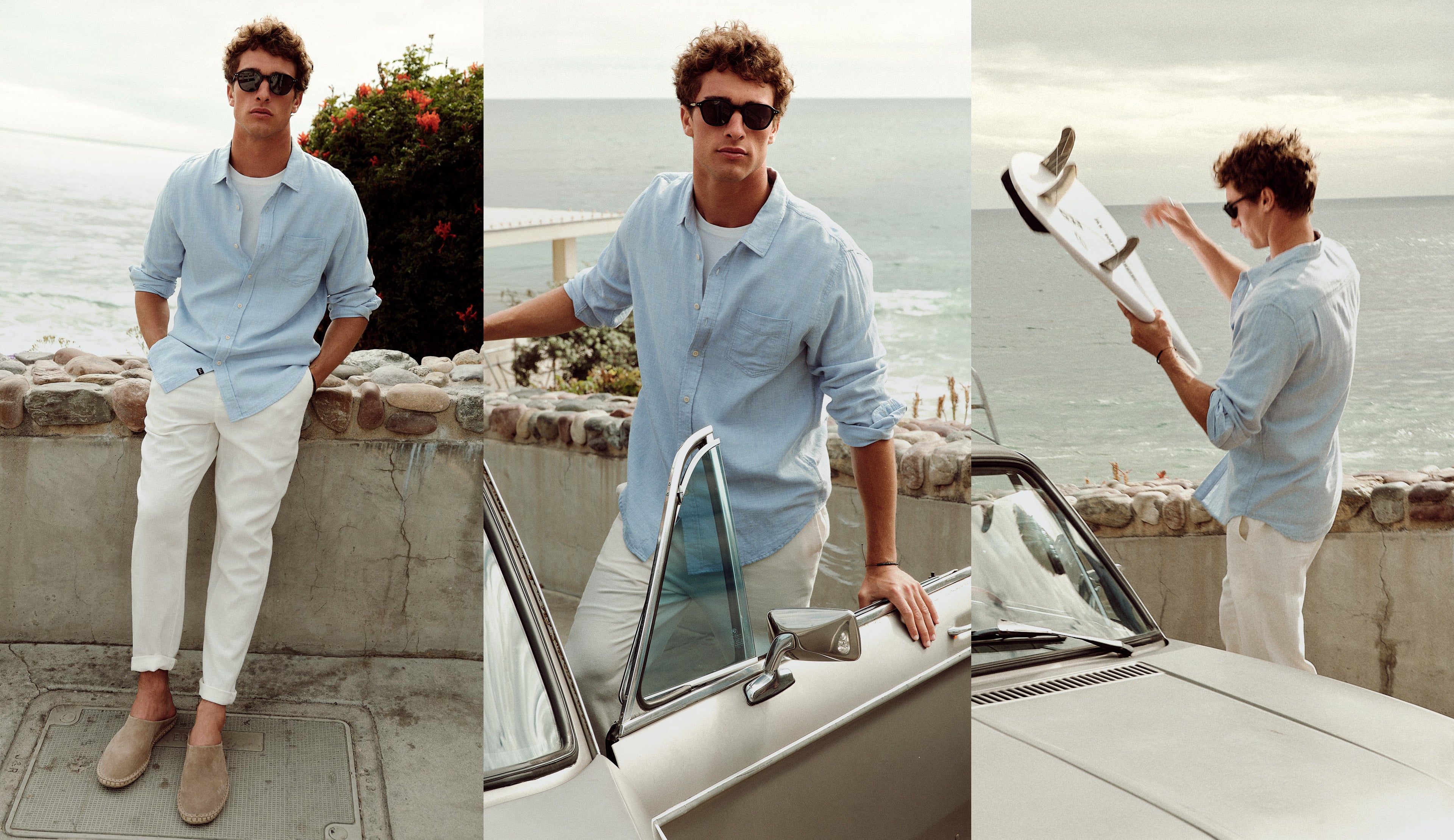 Man in light blue shirt and white pants standing by a car with ocean view