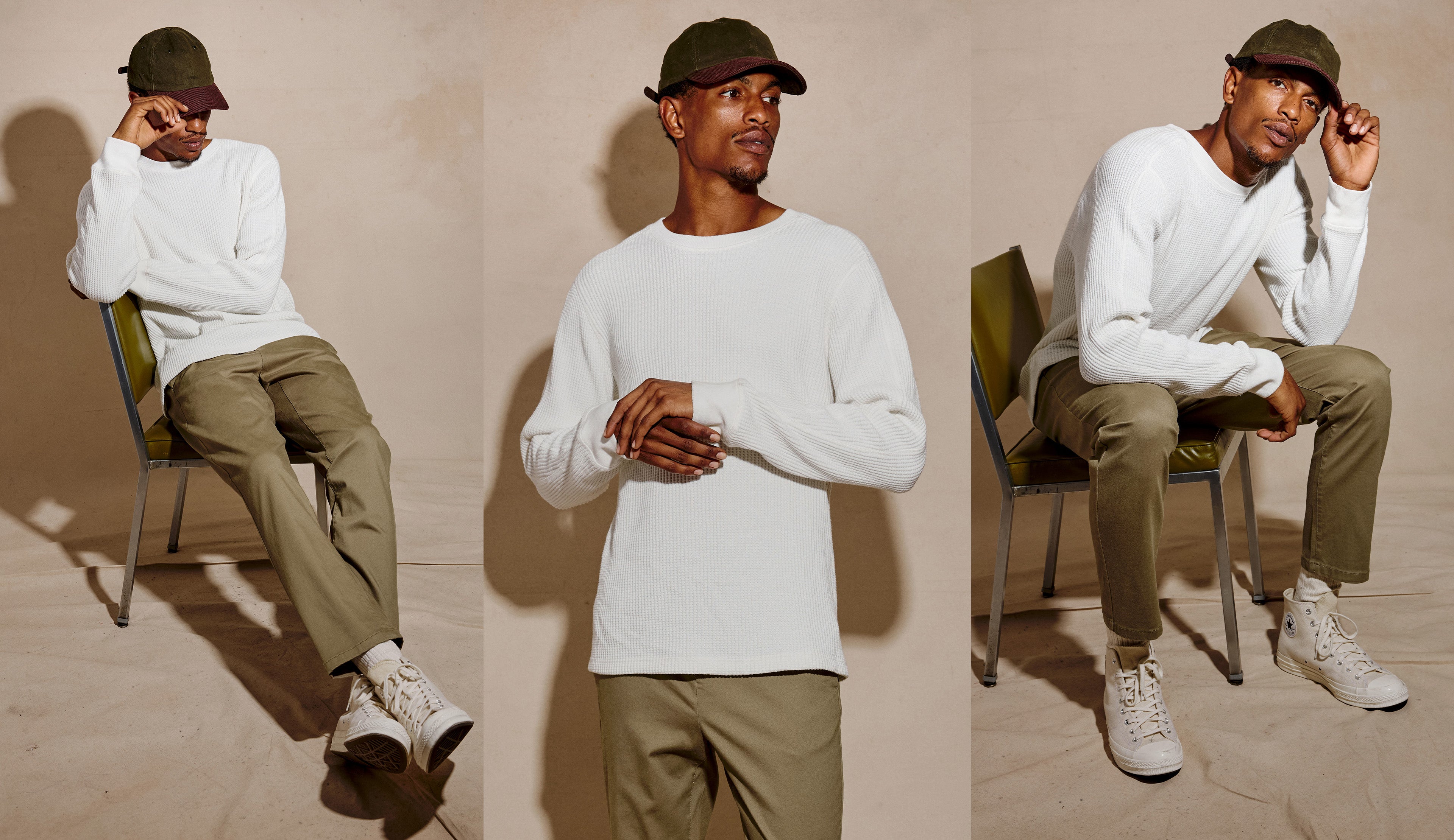 A three-panel fashion photo showing a man modeling a white long-sleeve crewneck shirt, olive green pants, white sneakers, and a dark green cap while sitting on and standing beside chairs against a warm beige studio backdrop.