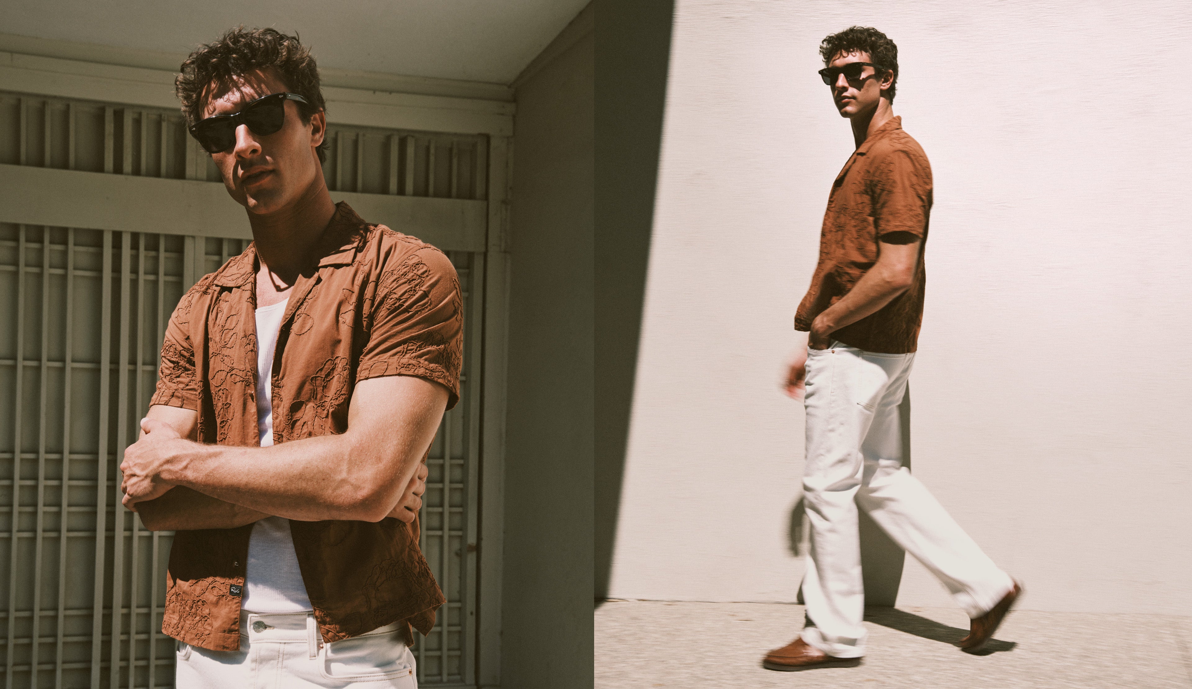 Man wearing sunglasses and a brown shirt standing against a wall.