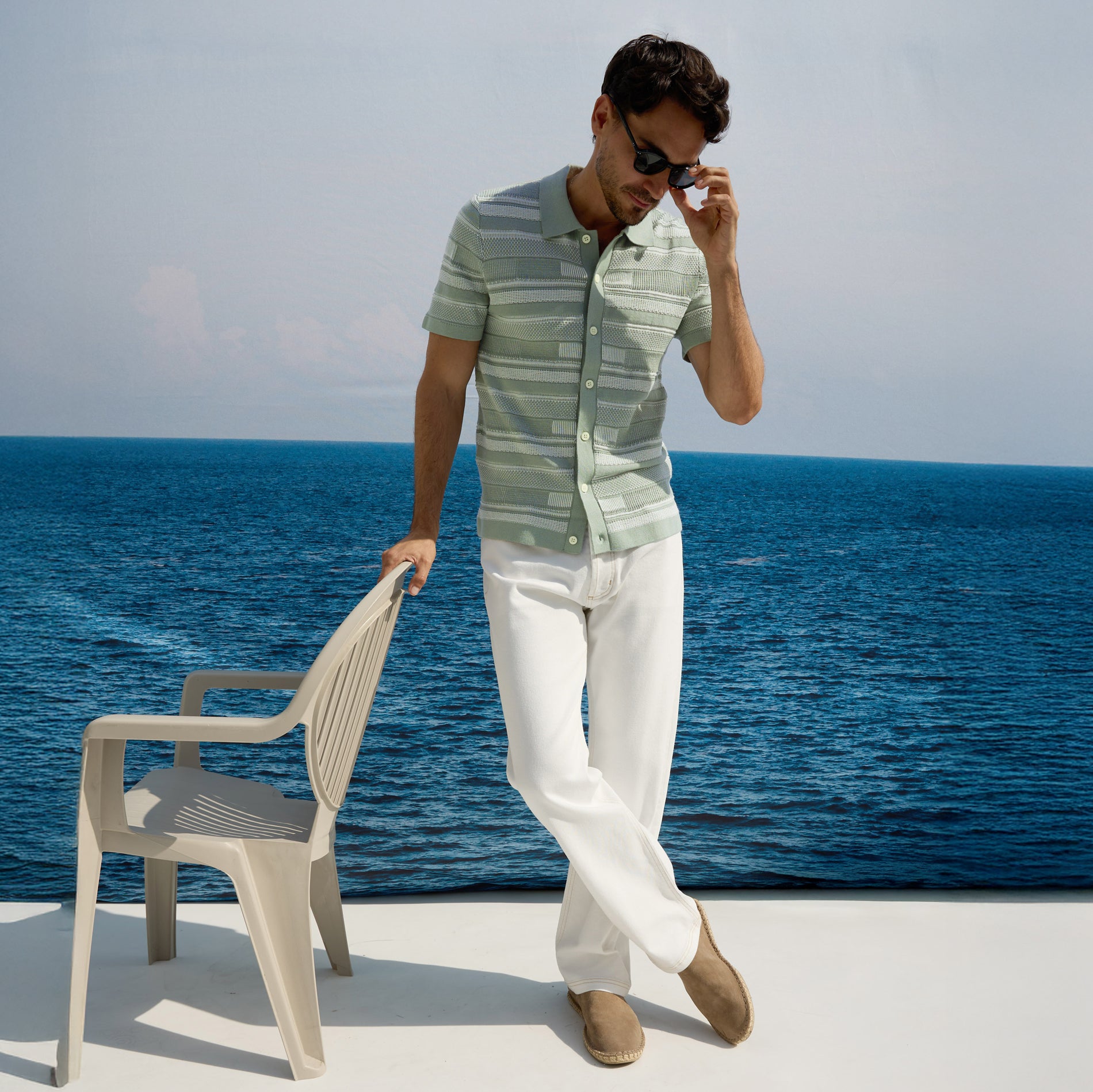 Man wearing green button down shirt with white pants dressed for summer