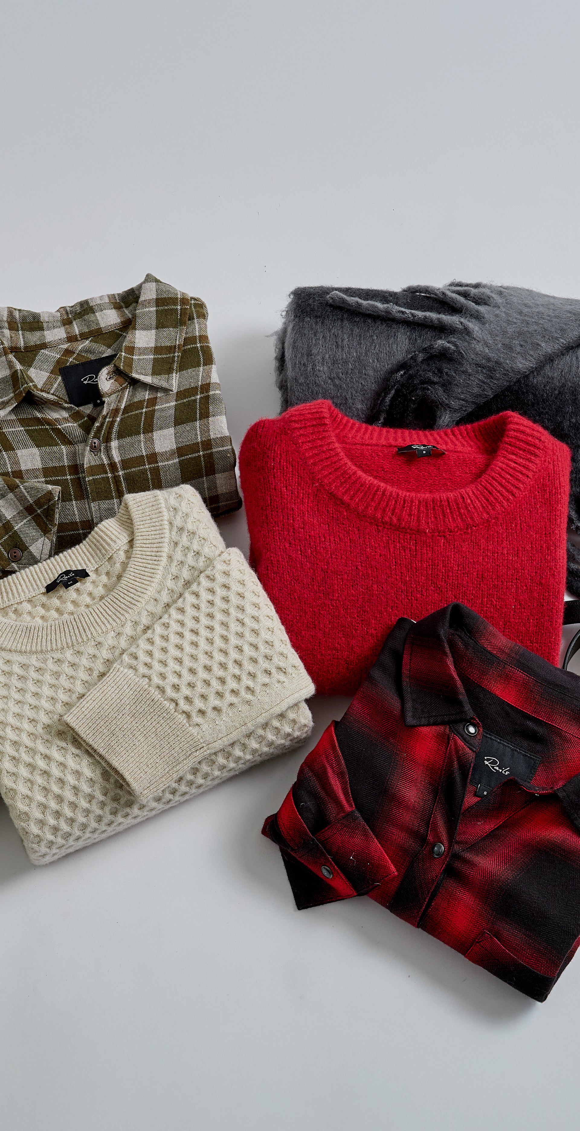 EDITORIAL IMAGE OF MULTIPLE SWEATERS AND SHIRTS FOLDED TOGETHER
