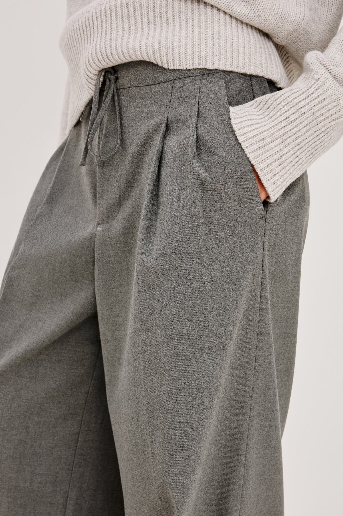 Nando Pant in Drapey Suiting Blend With High Waist, Wide, Relaxed Legs, and Drawstring Ties in Heather Charcoal Colorway - Side Detail Crop View Featured on Model.