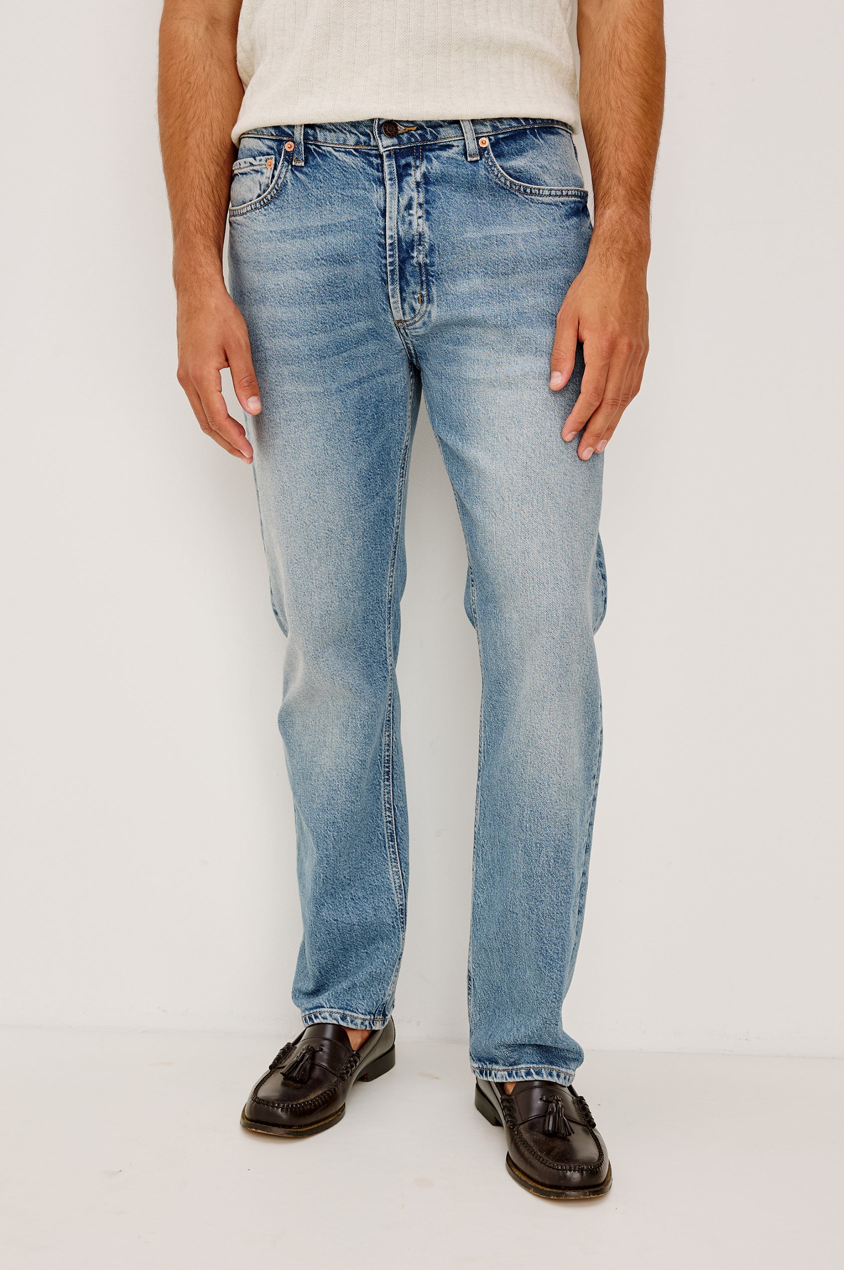Nash is a straight leg 5-Pocket denim jean a zip fly and button closure as well as rivets in a Medium Vintage Wash. Front view featured on model.