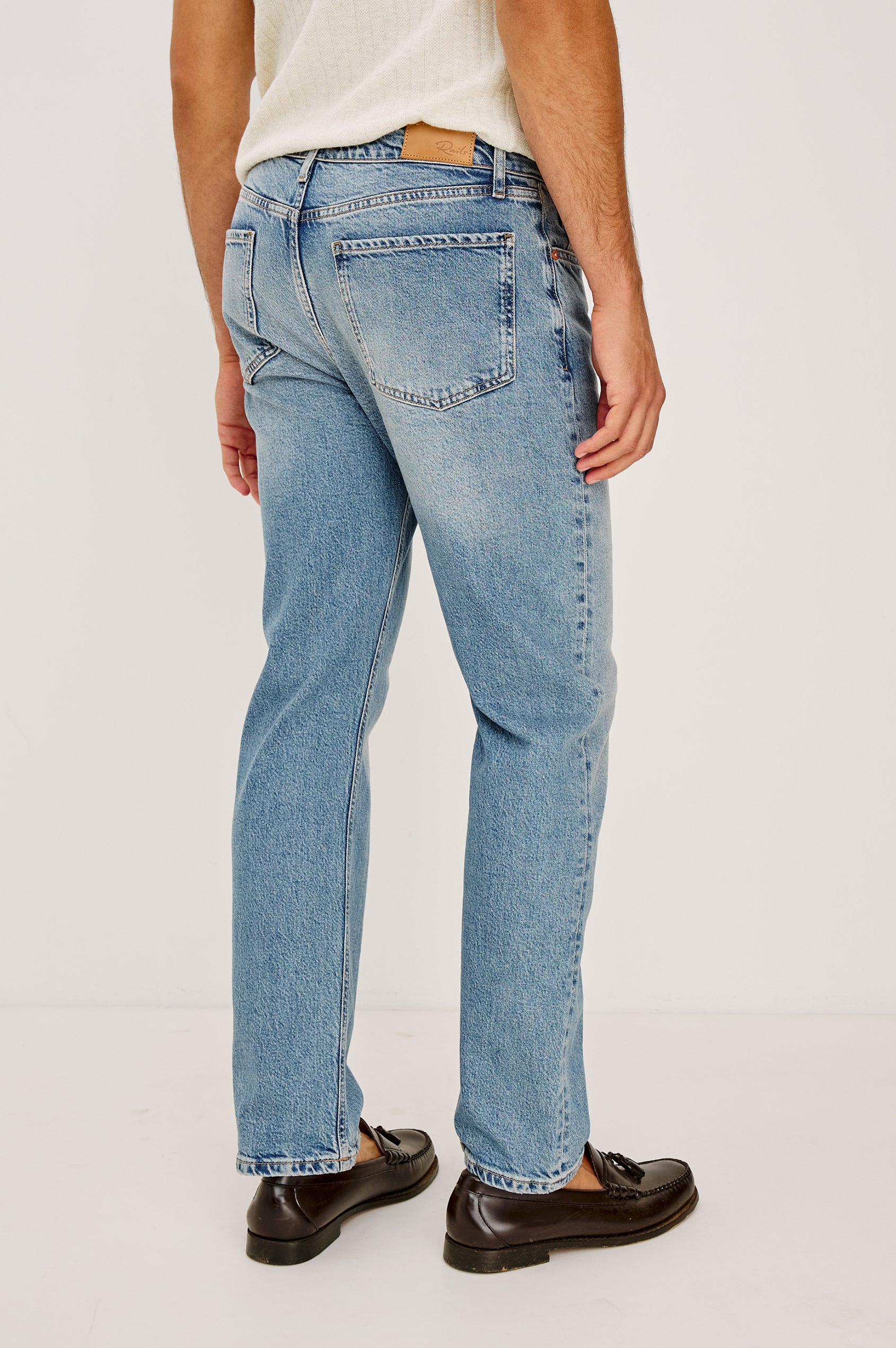 Nash is a straight leg 5-Pocket denim jean a zip fly and button closure as well as rivets in a Medium Vintage Wash. Back body view featured on model.