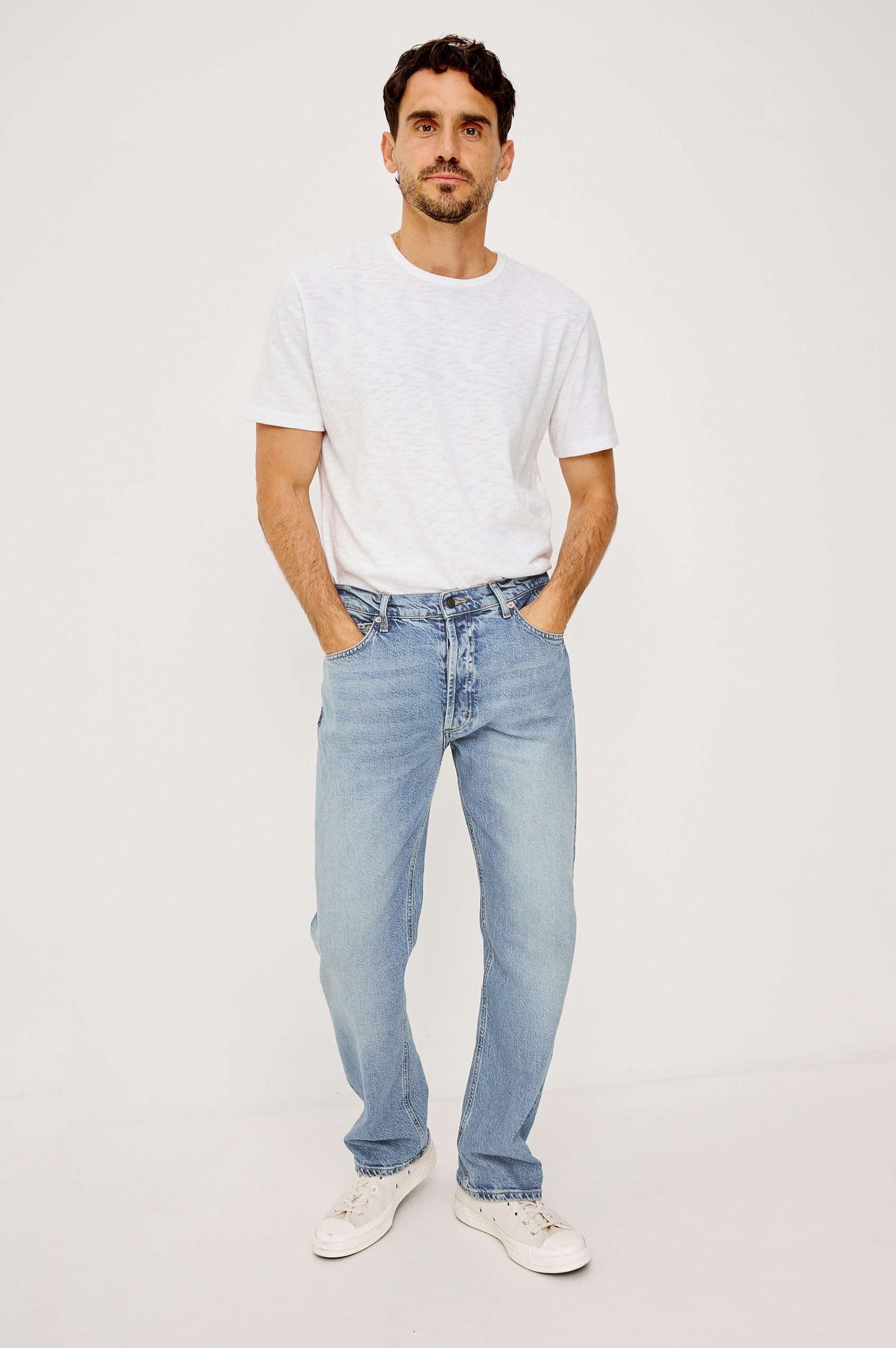 Nash is a straight leg 5-Pocket denim jean a zip fly and button closure as well as rivets in a Ranchwater Wash. Front view featured on model.