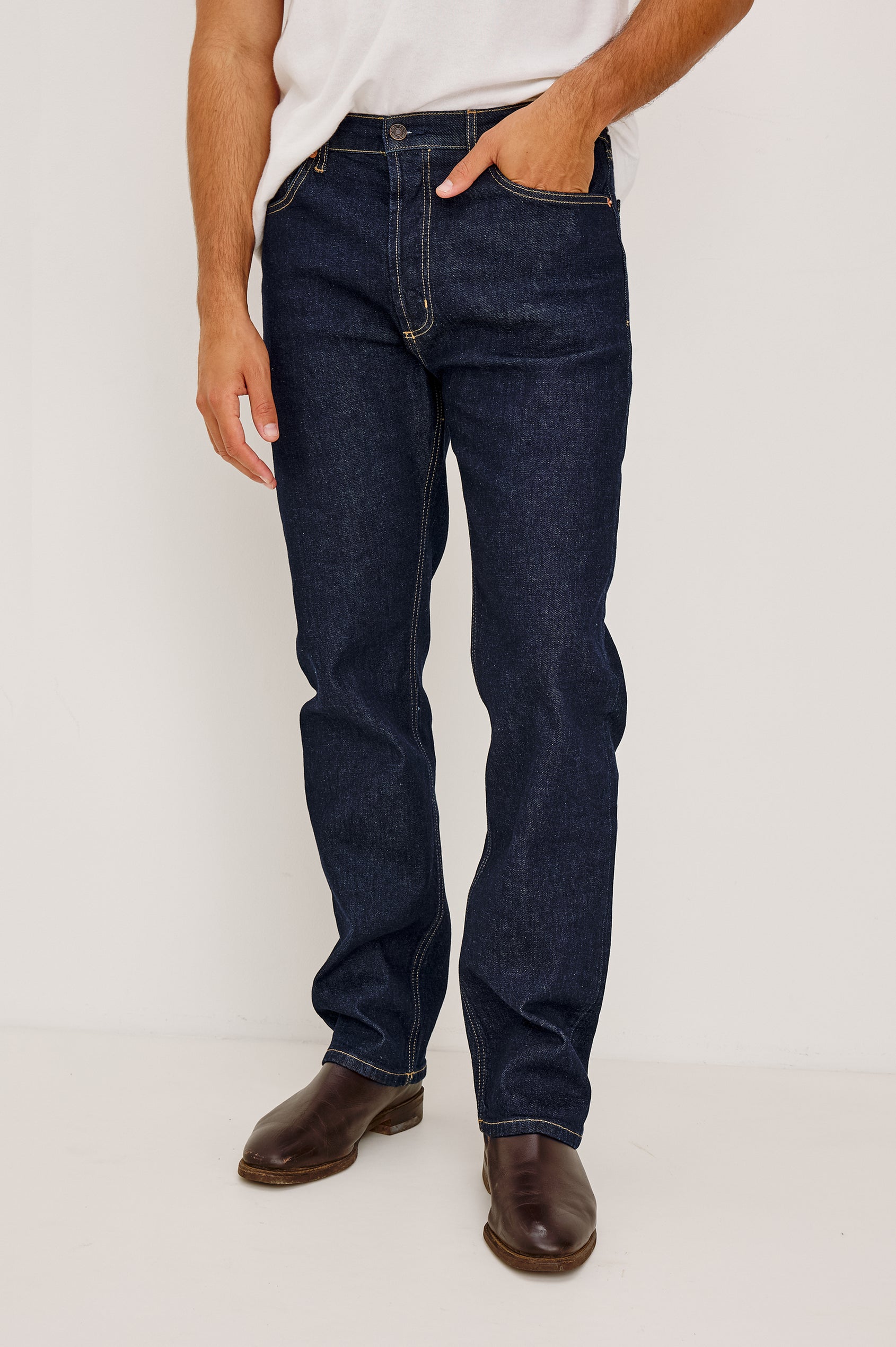 Nash is a straight leg 5-Pocket denim jean a zip fly and button closure as well as rivets in a Rinse Wash. Front view featured on model.