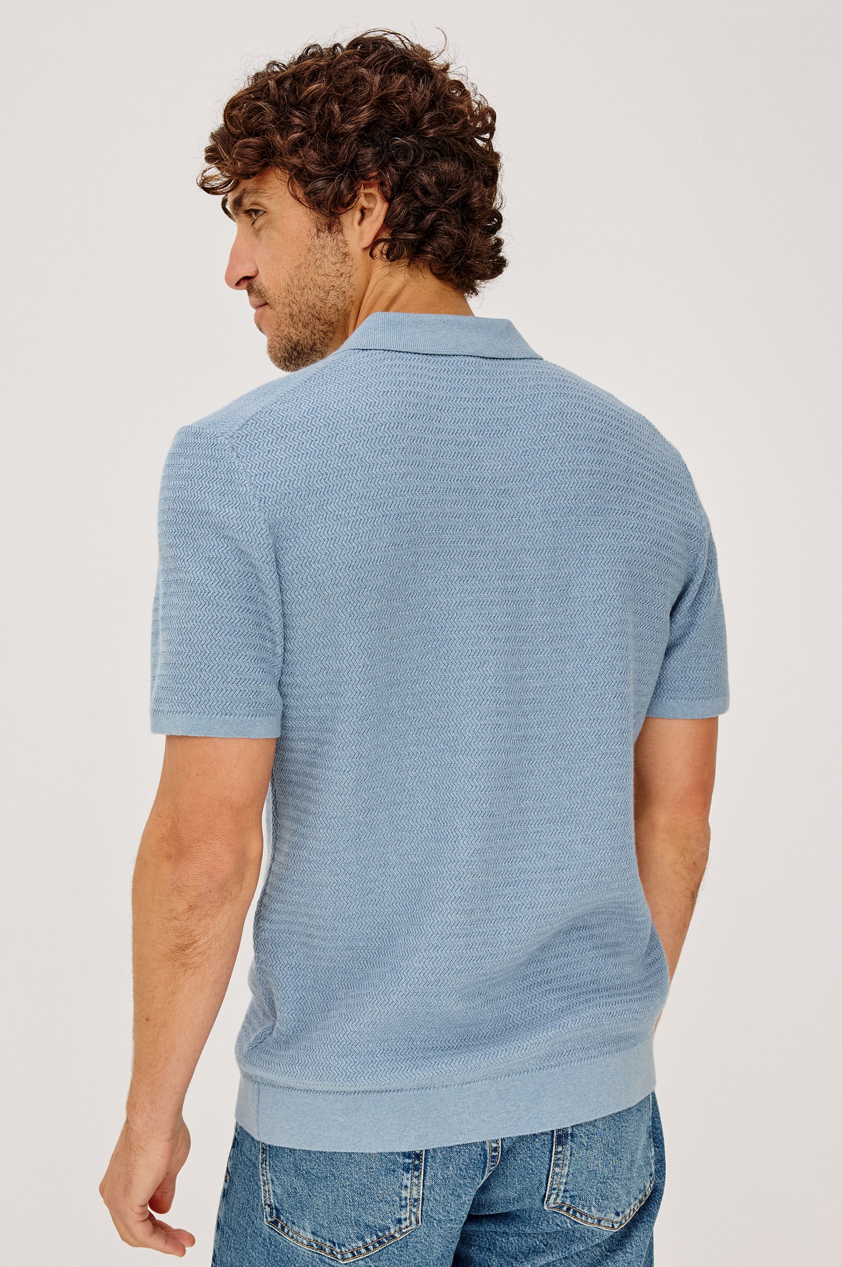 Nathan Polo Shirt in Cotton Blend Knit With Collar, Quarter Button Placket, and Short Sleeves in Blue Sky Heather Colorway - Upper Body Back View Featured on Model