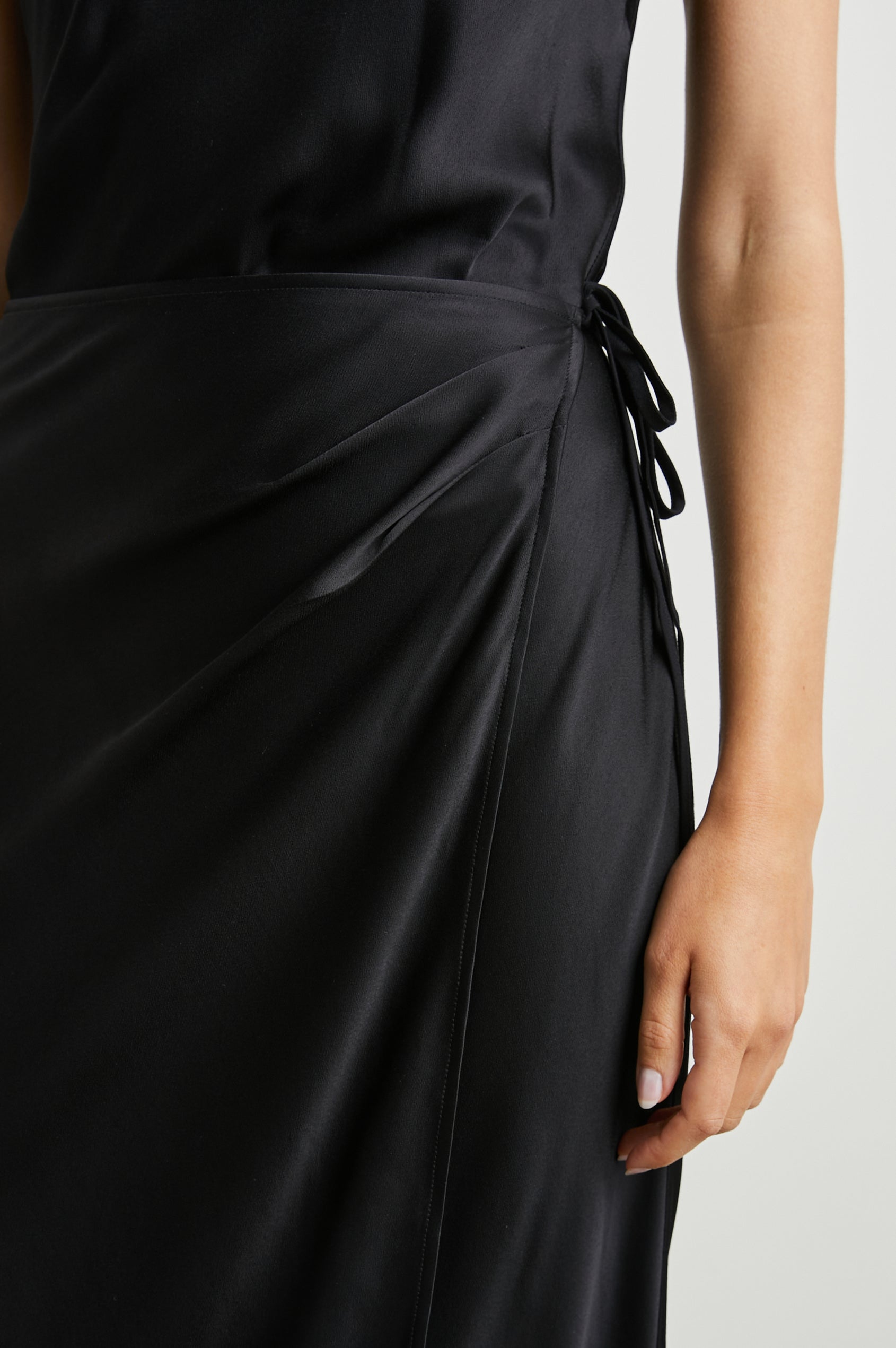 Navi Sleeveless Midi Dress with a Halter Neckline with a Back Tie Keyhole, and a Wrap Skirt with a Side Tie Closure in Black Colorway - Front View Featured on Model  