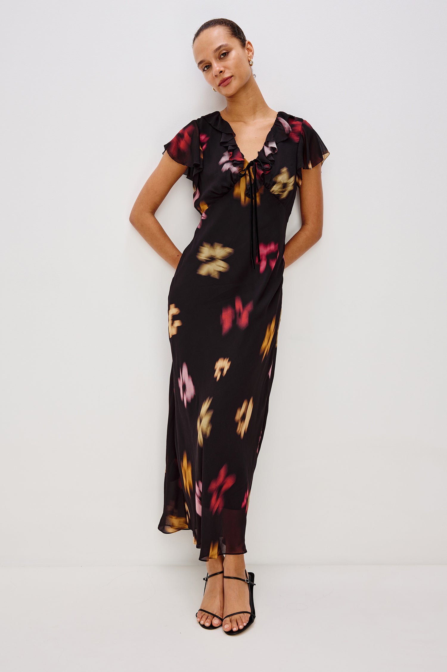 Neela Midi Dress in Chiffon With Ruffle V-Neckline, Center Front Self-Ties, Ruffled Cap Sleeves, and Empire Waistline in Blurred Floral Colorway - Full Body Front View Featured on Model