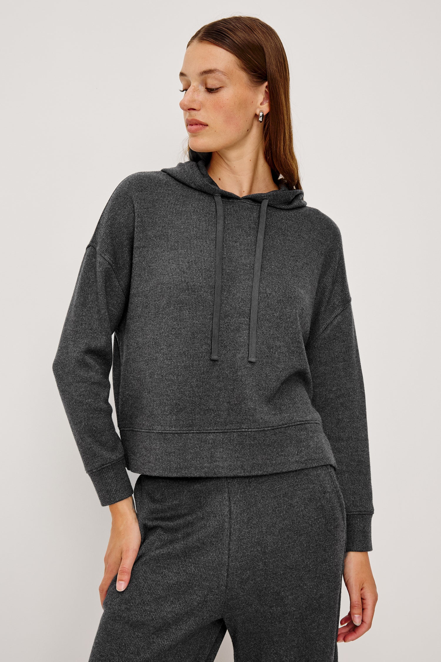 Nico is a hoodie in brushed rib lounge fabrication, with a relaxed fit and drop shoulders in charcoal colorway. Front view featured on model.