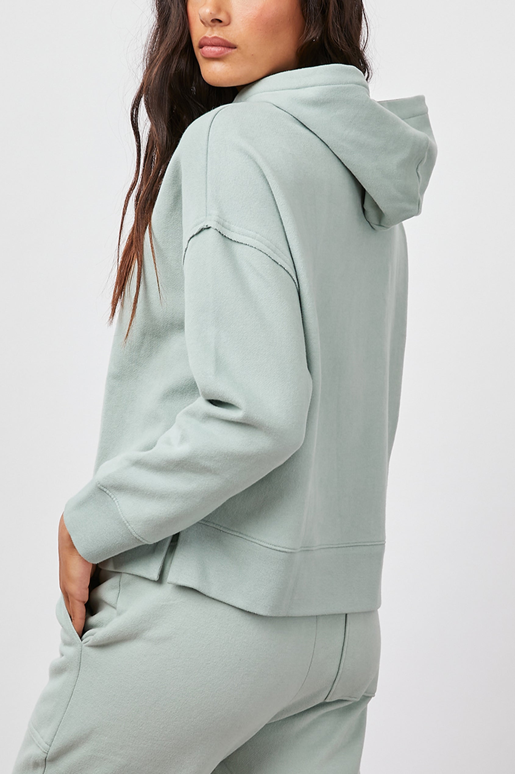 Nico & Edna Set with a Sweatshirt with a Hood and Pants with Two Large Front Pockets and One Back Patch Pocket in Light Seafoam Colorway - Side View Featured on Model 