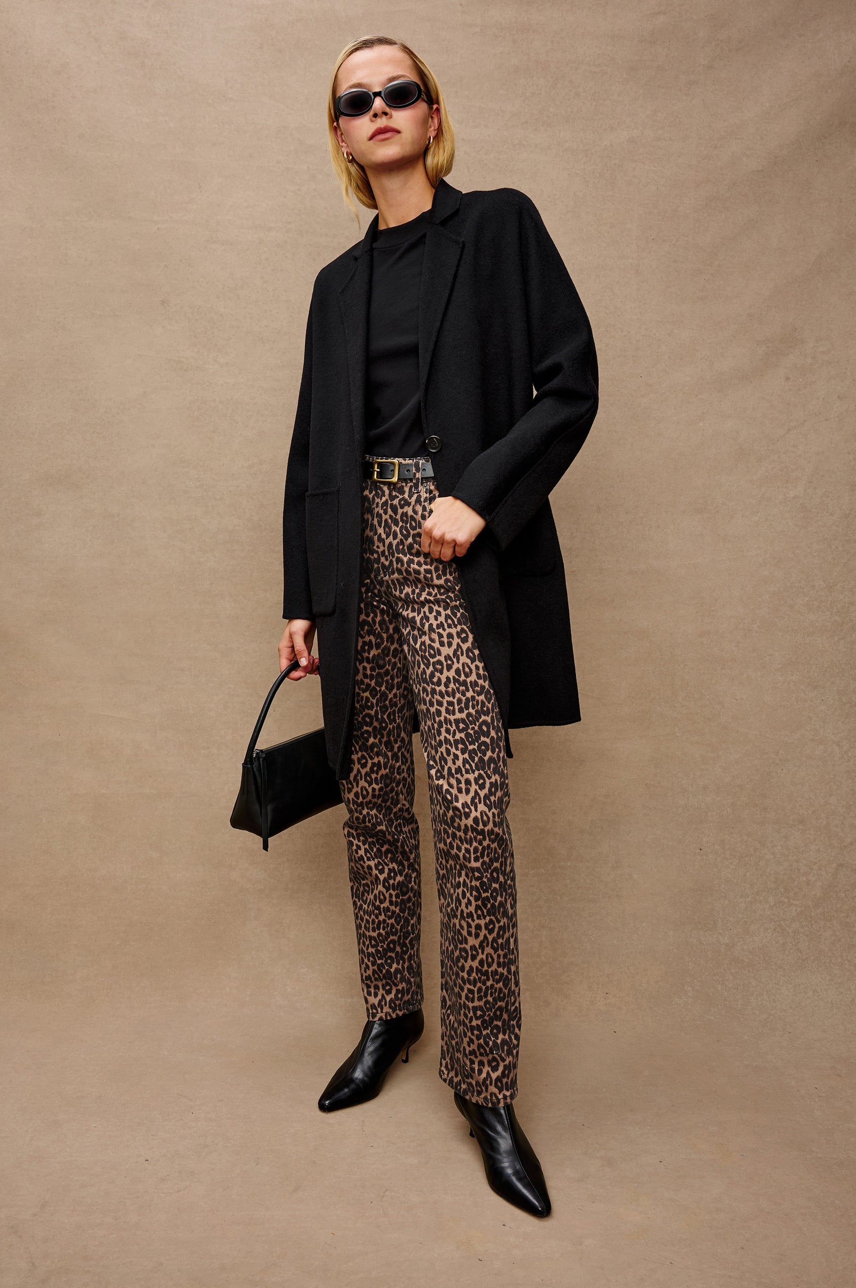 Everest Mid-Thigh Length Coat with Single Button Closure, Notched Lapels and Front Patch Pockets in Black Colorway - Stylized Front Full Body View Featured on Model