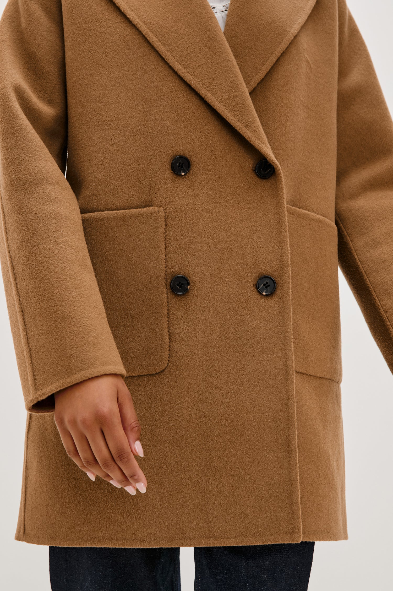 Nily Mid-Thigh Length, Double-Breasted Coat with Two Button Closure, Two Front Patch Pockets and a Shaw Collar in Camel Colorway - Close Up View Featured on Model 