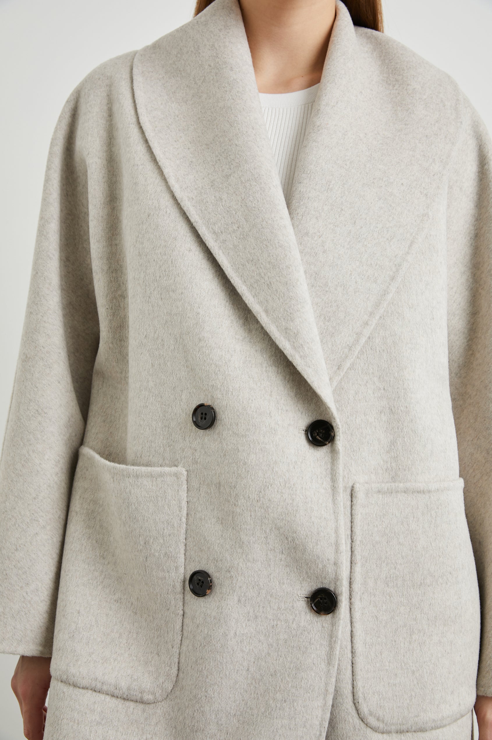 Nily Mid-Thigh Length, Double-Breasted Coat with Two Button Closure, Two Front Patch Pockets and a Shaw Collar in Oatmeal Colorway - Front View Featured on Model 