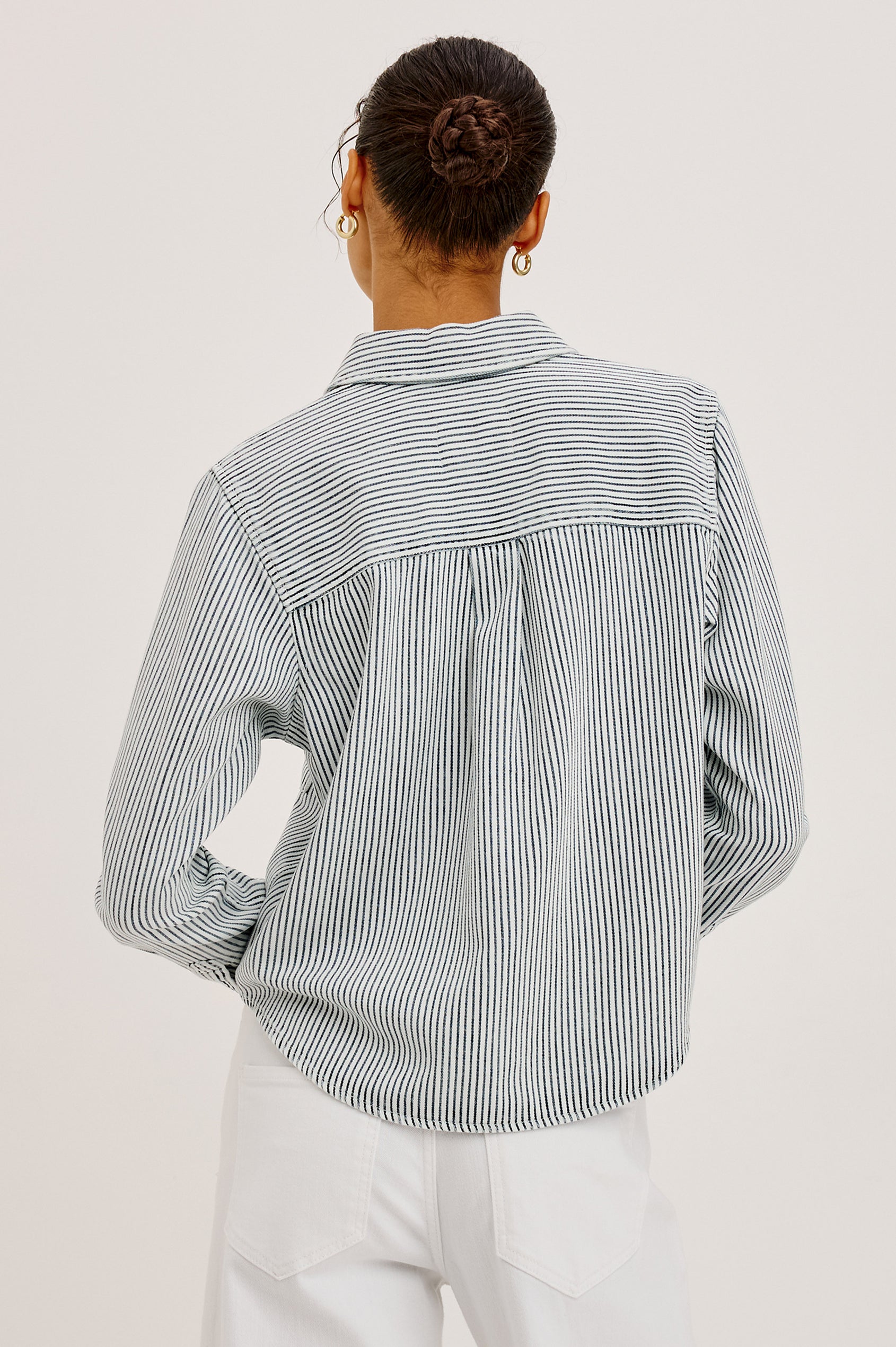 Noa Crop Denim Shirt With Boxy Fit, Front Snap Buttons, a Chest Patch Pocket, and Long Sleeves in Railroad Stripe Colorway - Upper Body Back View Featured on Model