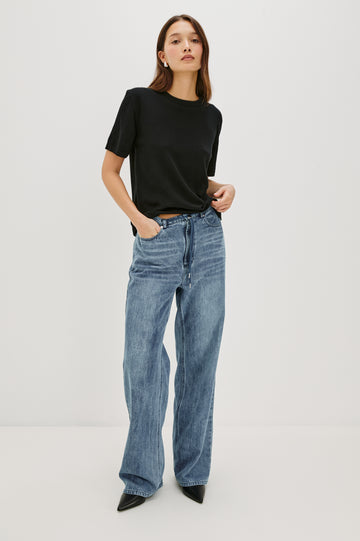 Normandie Lightweight 5-Pocket Denim Wide Leg Pant with front zipper button fly and a drawstring tie at waist in Antique Blue Colorway. Front Full Body View Featured on Model.