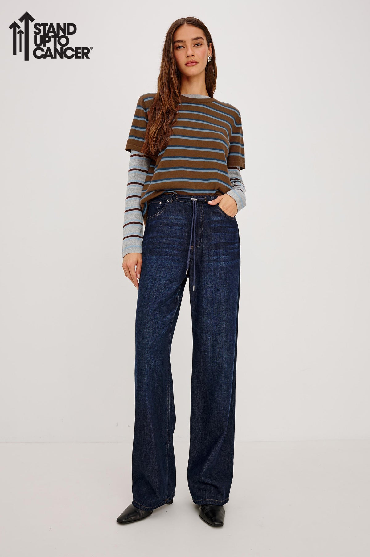 Normandie Pant in Cotton-Lyocell Blend With Relaxed Wide Legs, Drawstring Waistband, Zip Fly, and 5-Pockets in Rinse Wash Colorway - Full Body Front View Featured on Model with Stand Up To Cancer Logo on Image Top Left