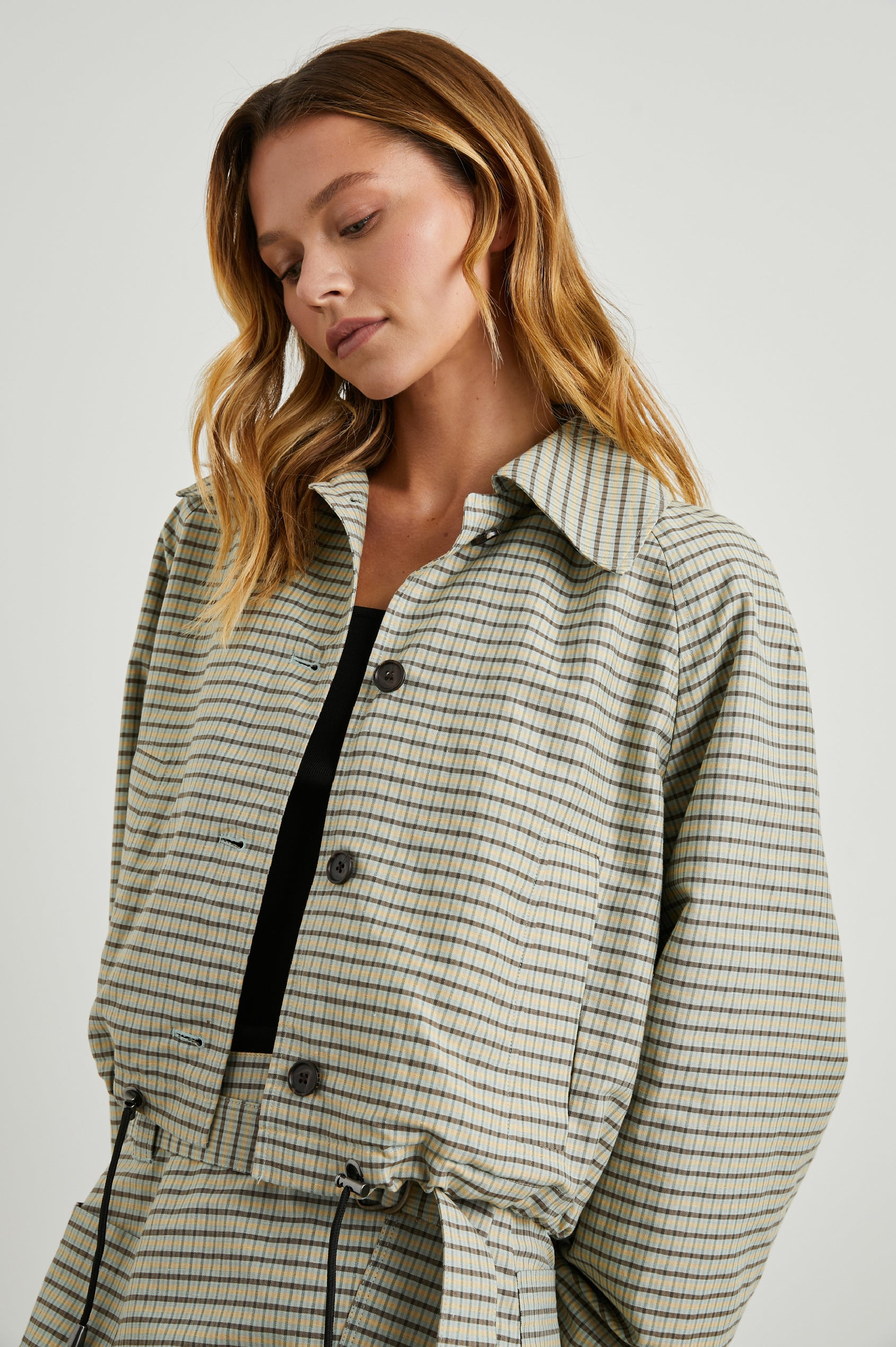 North Cropped Jacket with Button Closure, Puff Sleeves, Oversize Collar, a Toggle Hem, Two Front Pockets and a Horizontal Back Vent in Sage Mini Check Colorway, a Brown, Yellow and Sage Plaid - Front View Featured on Model