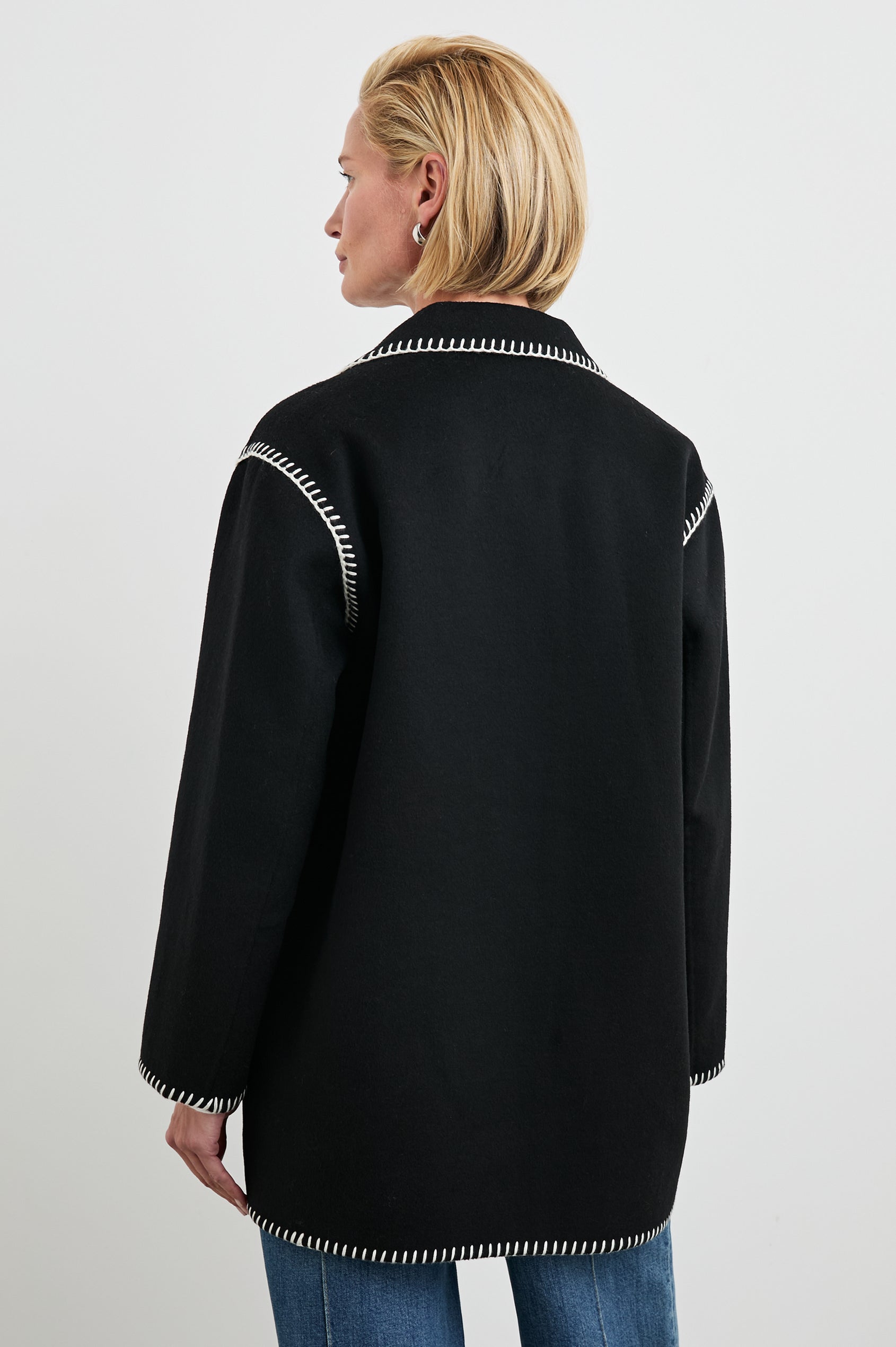 Odyssey Jacket with Four Button Closure and a Chest Patch Pocket in Black Colorway, with white contrast stitching - Back View Featured on Model