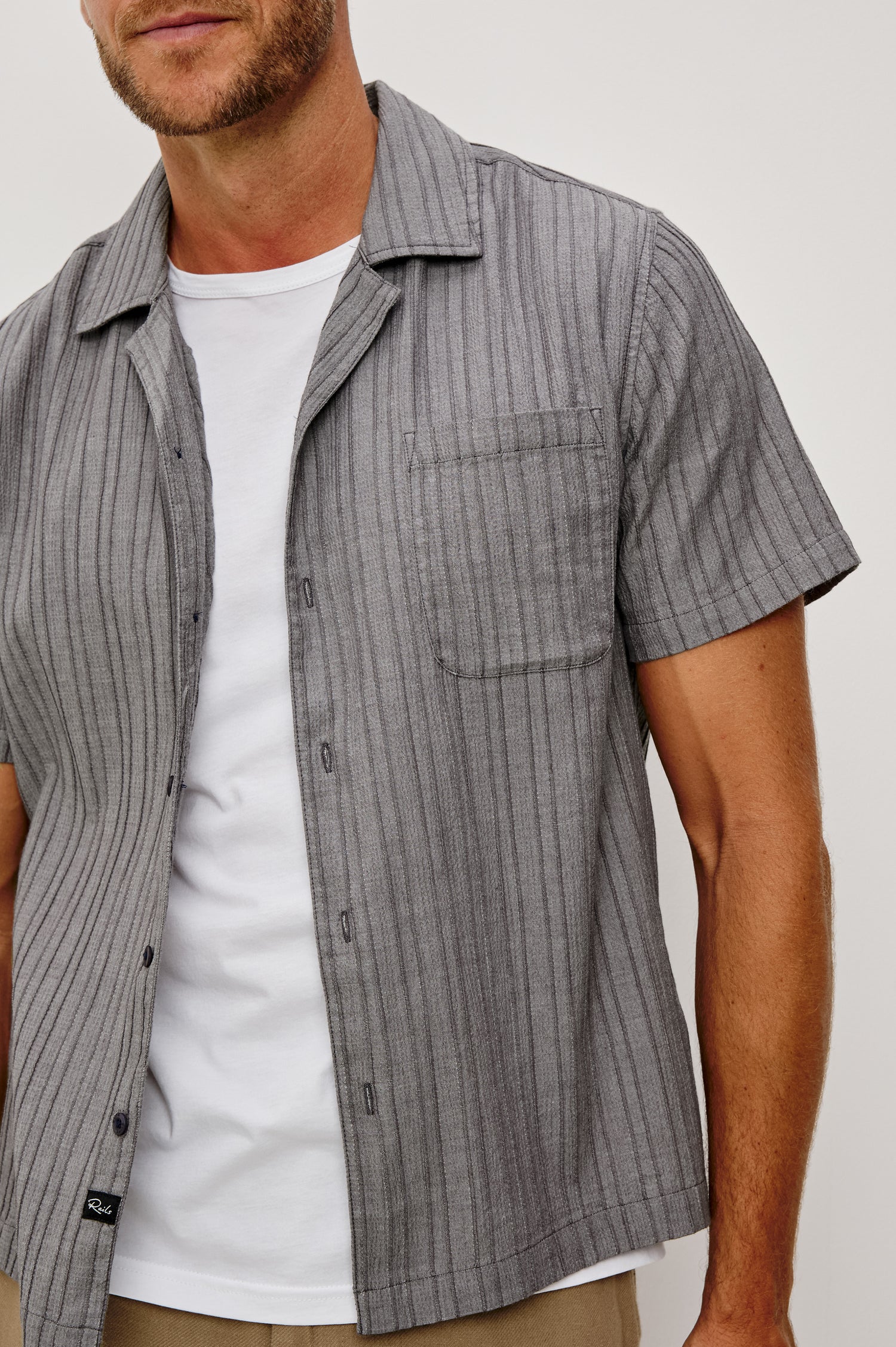 Ohana Button-Up Shirt in Textured Shirting WIth Short Sleeves, Collar, and Relaxed Fit in Charcoal Chambray Colorway - Upper Body Front Close Up View Featured on Model