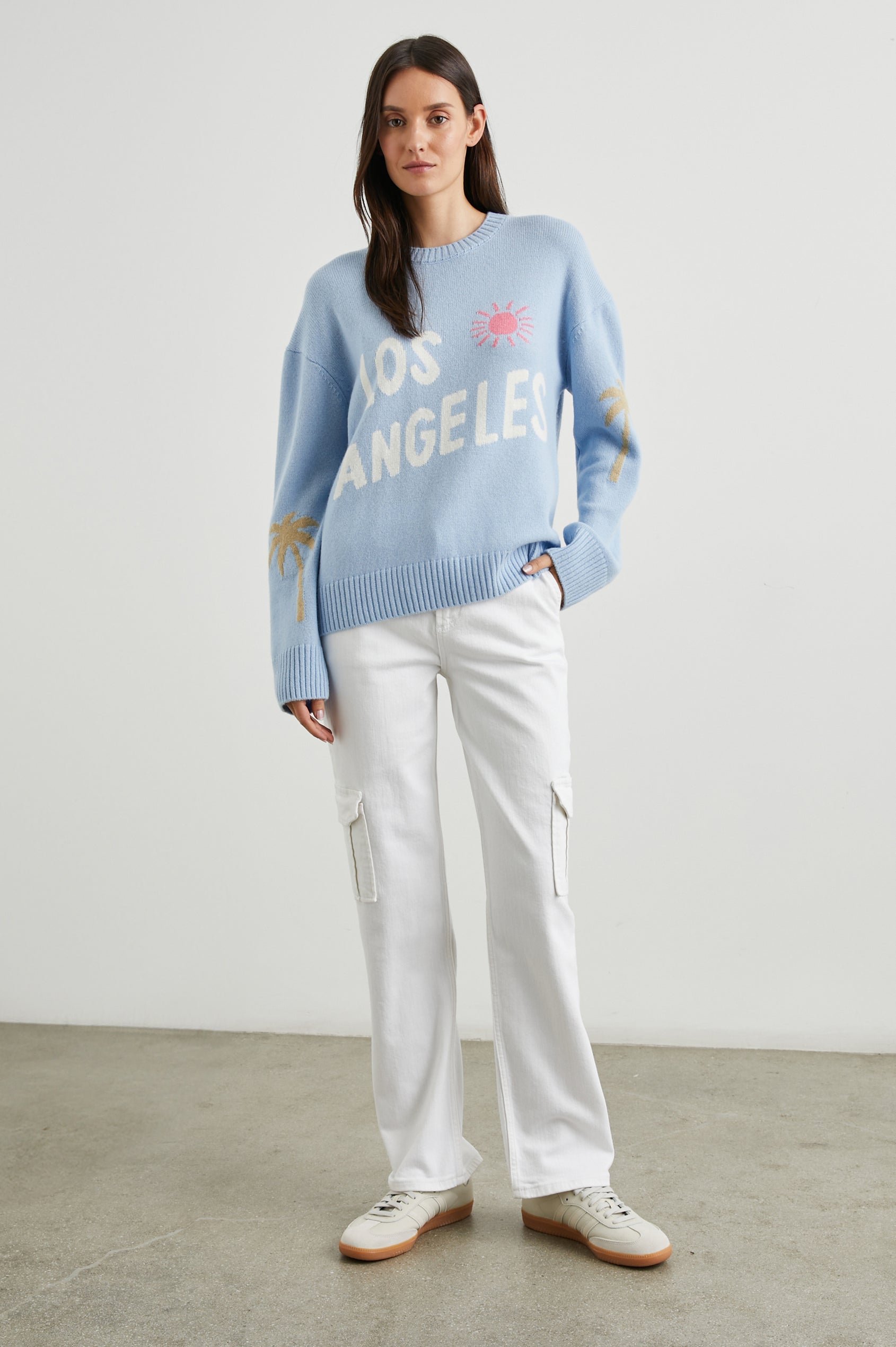 Olivia Long-Sleeve Sweater with a Crew Neck, a Pink Sun and Gold Palm Trees and the White Text, Los Angeles, in Los Angeles Blue Colorway - Front Full Body View Featured on Model  