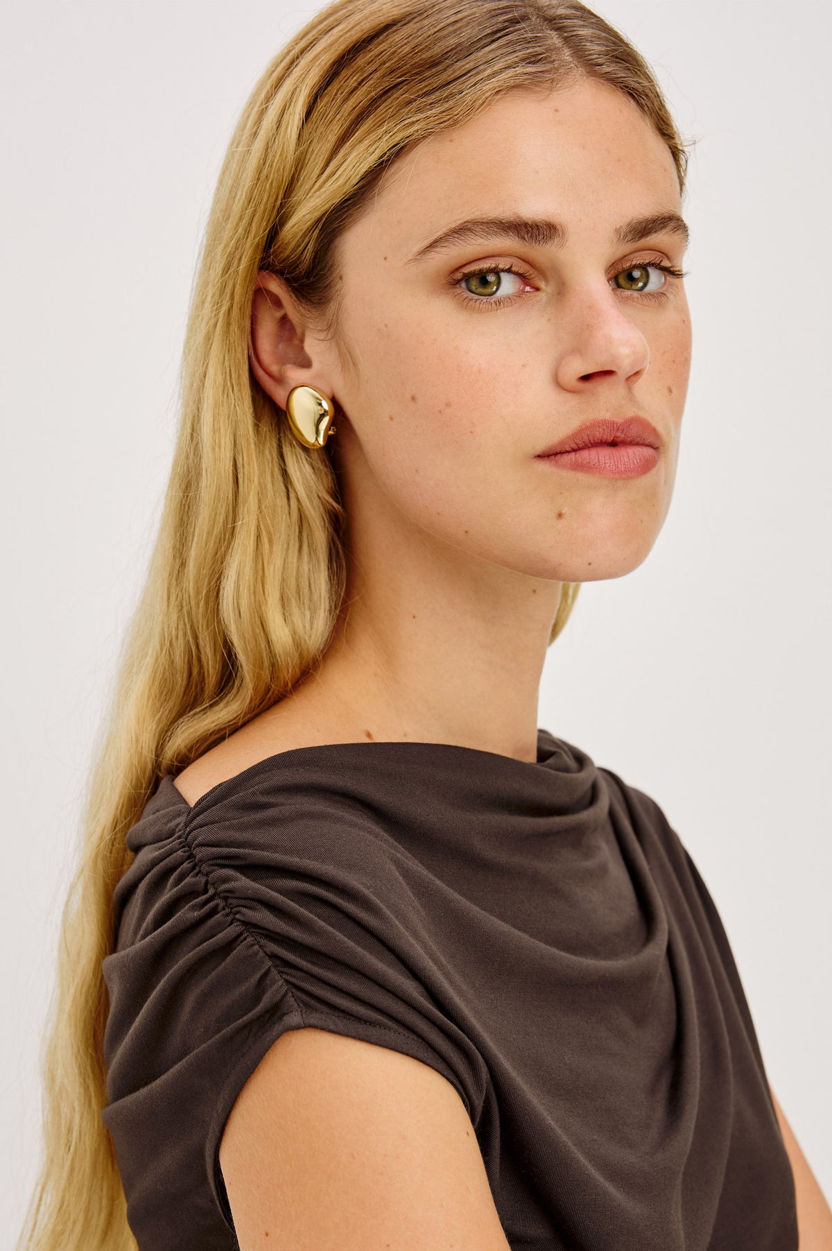 Organic Shaped Dome Earrings With Push Back Post Closure in Gold Colorway - Side View Featured on Model