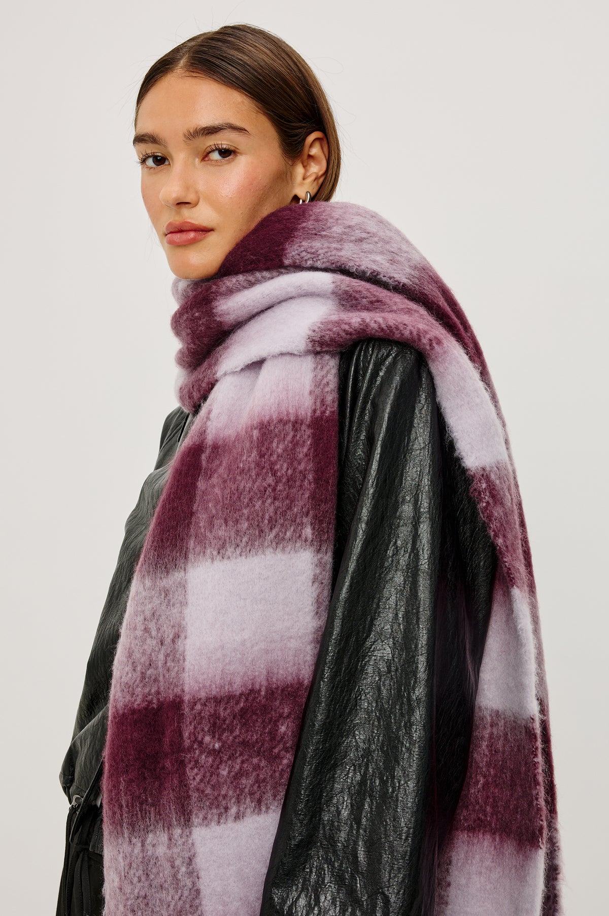 Oslo Oversized Knit Scarf With Fringe Trim in Wine Lilac Check Colorway - Upper Body Side View Featured on Model