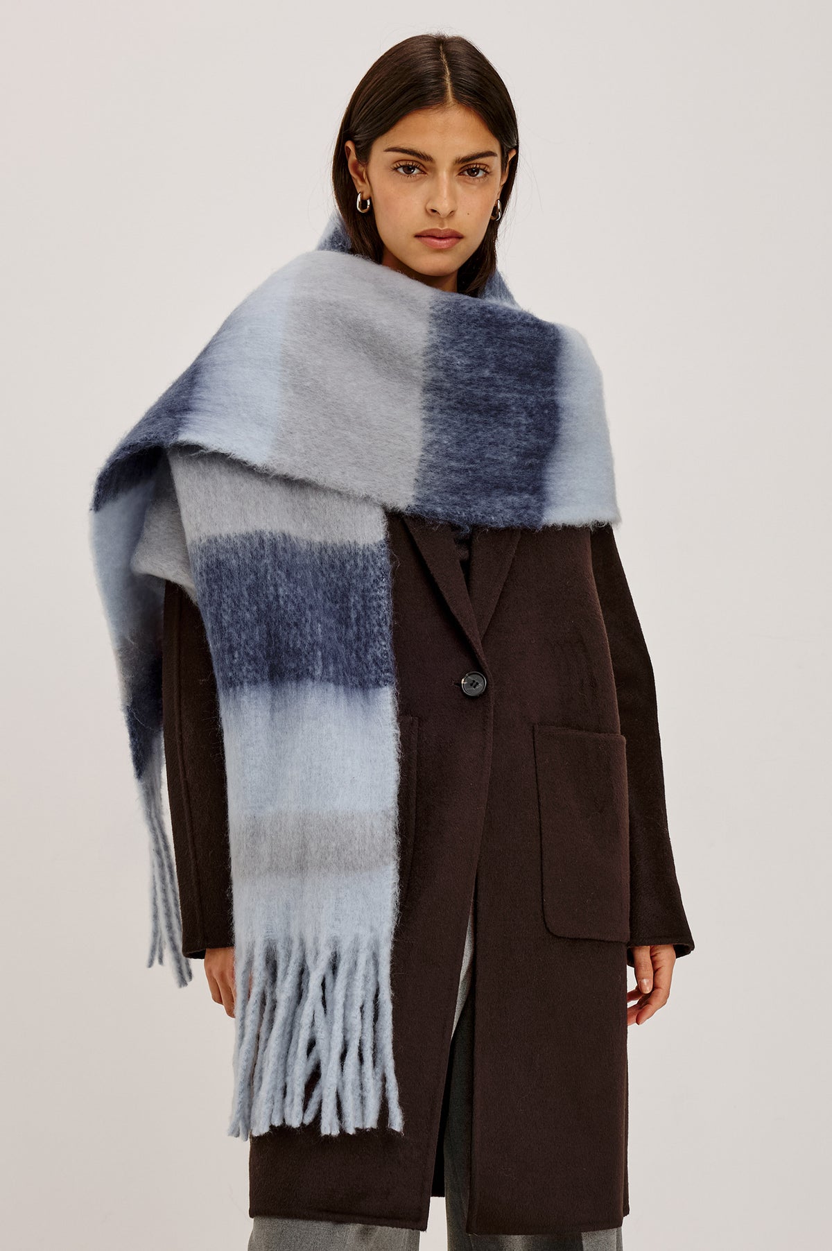 Oslo Scarf in Brushed Polyester Knit With Oversized Shape and Fringe Trim in Sky Indigo Stripe Colorway - Front View Featured on Model.