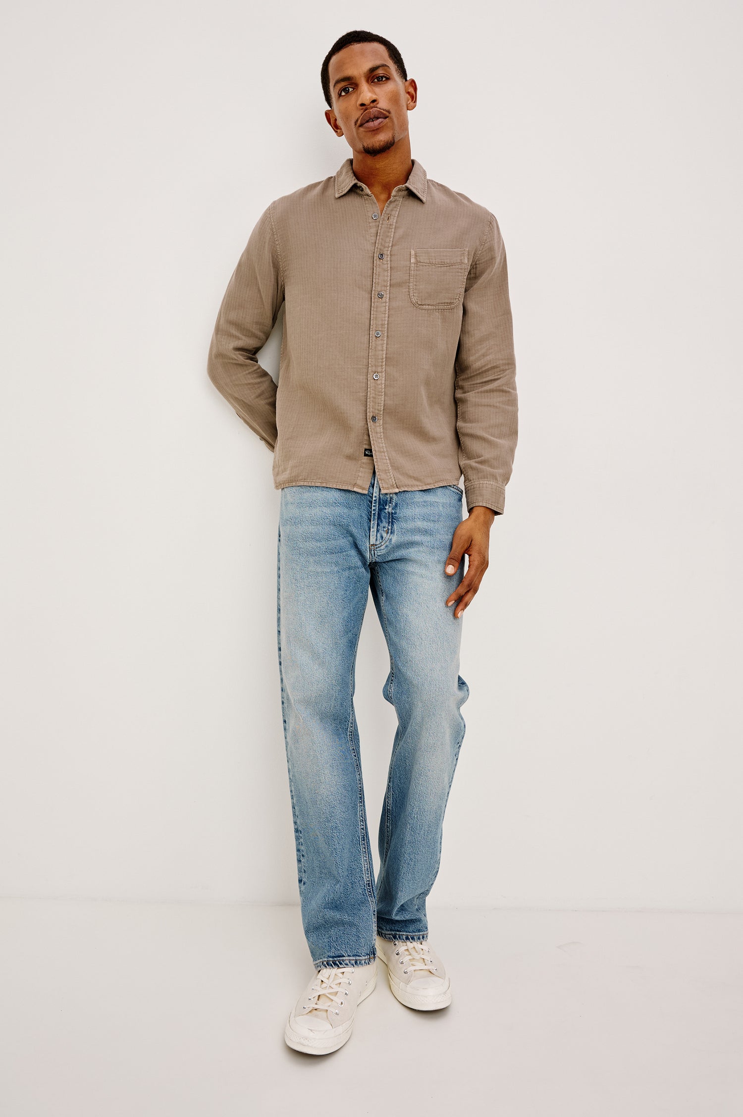Owens is a long sleeve, collared, button front shirt in lightweight cotton, long sleeve, and features a subtle pattern variation on the backside of the fabric in Desert Path colorway. Front detail view featured on model.