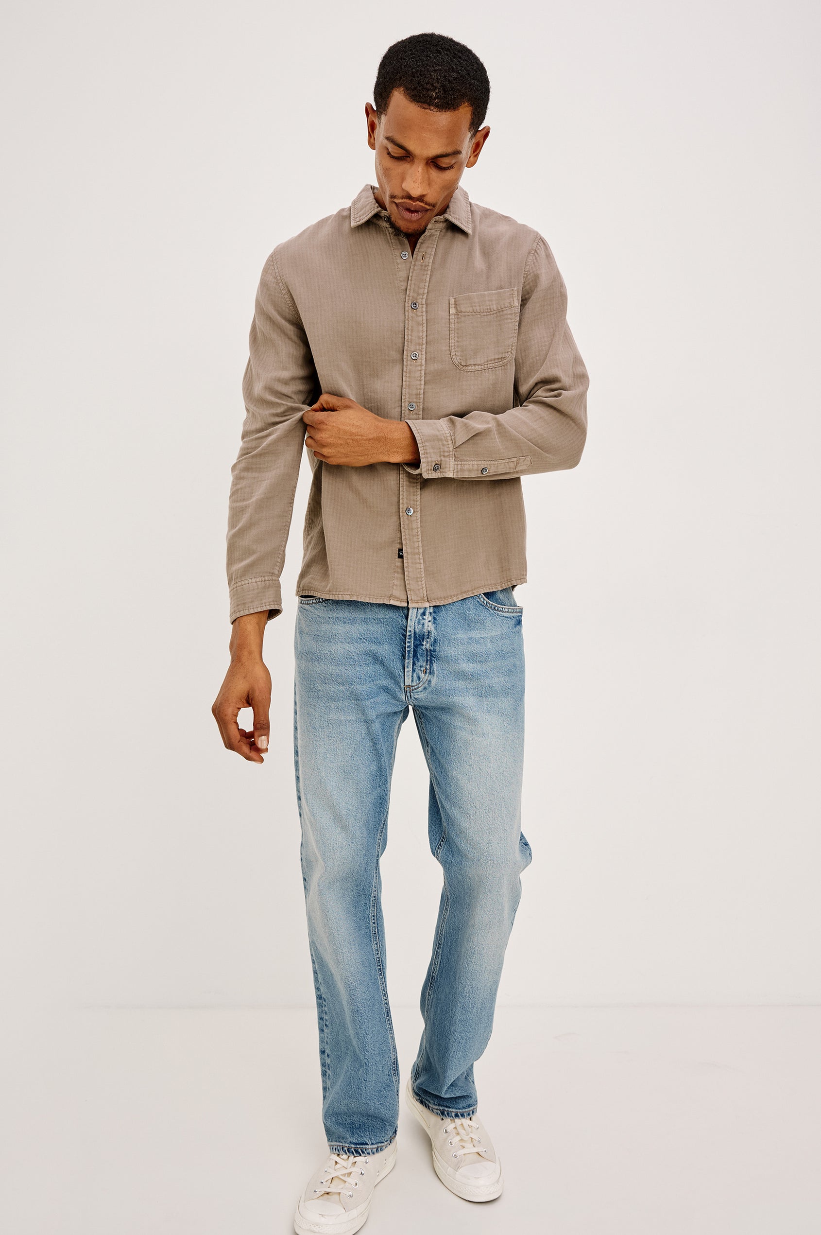 Owens is a long sleeve, collared, button front shirt in lightweight cotton, long sleeve, and features a subtle pattern variation on the backside of the fabric in Desert Path colorway. Front full body view featured on model.