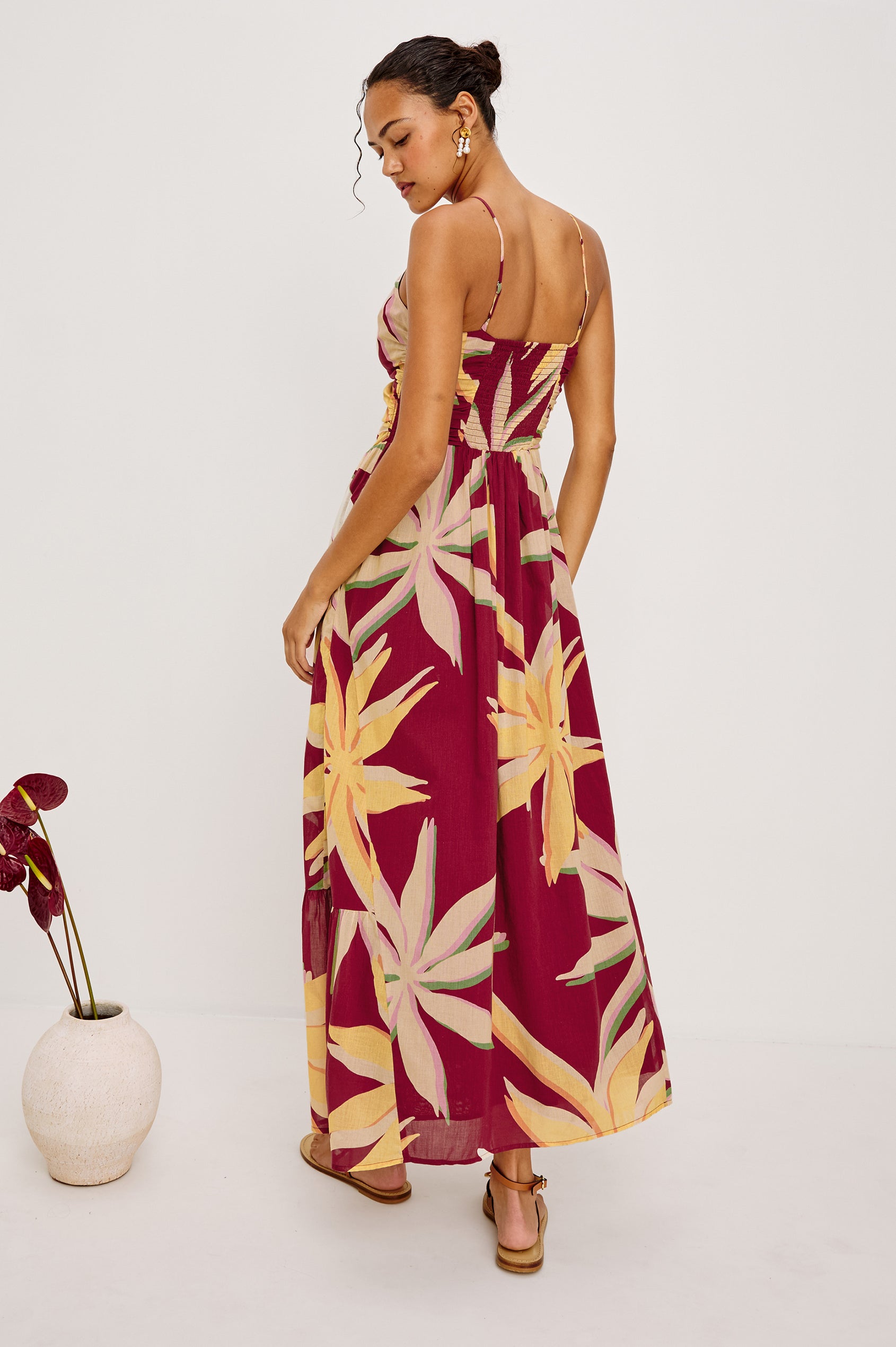 Palm Maxi Dress in Beach Cotton WIth Fitted Shirred Bodice V-Neckline Adjustable Shoulder Straps With Wooden Bead Detailing and Tiered Skirt in Red Palma Colorway - Full Body Back View Featured on Model
