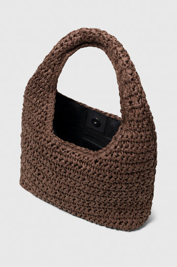 Palma Rattan Shoulder Bag with a Snap Closure and an Interior Pocket in Dark Brown Colorway. Image of bag interior with snap closure.