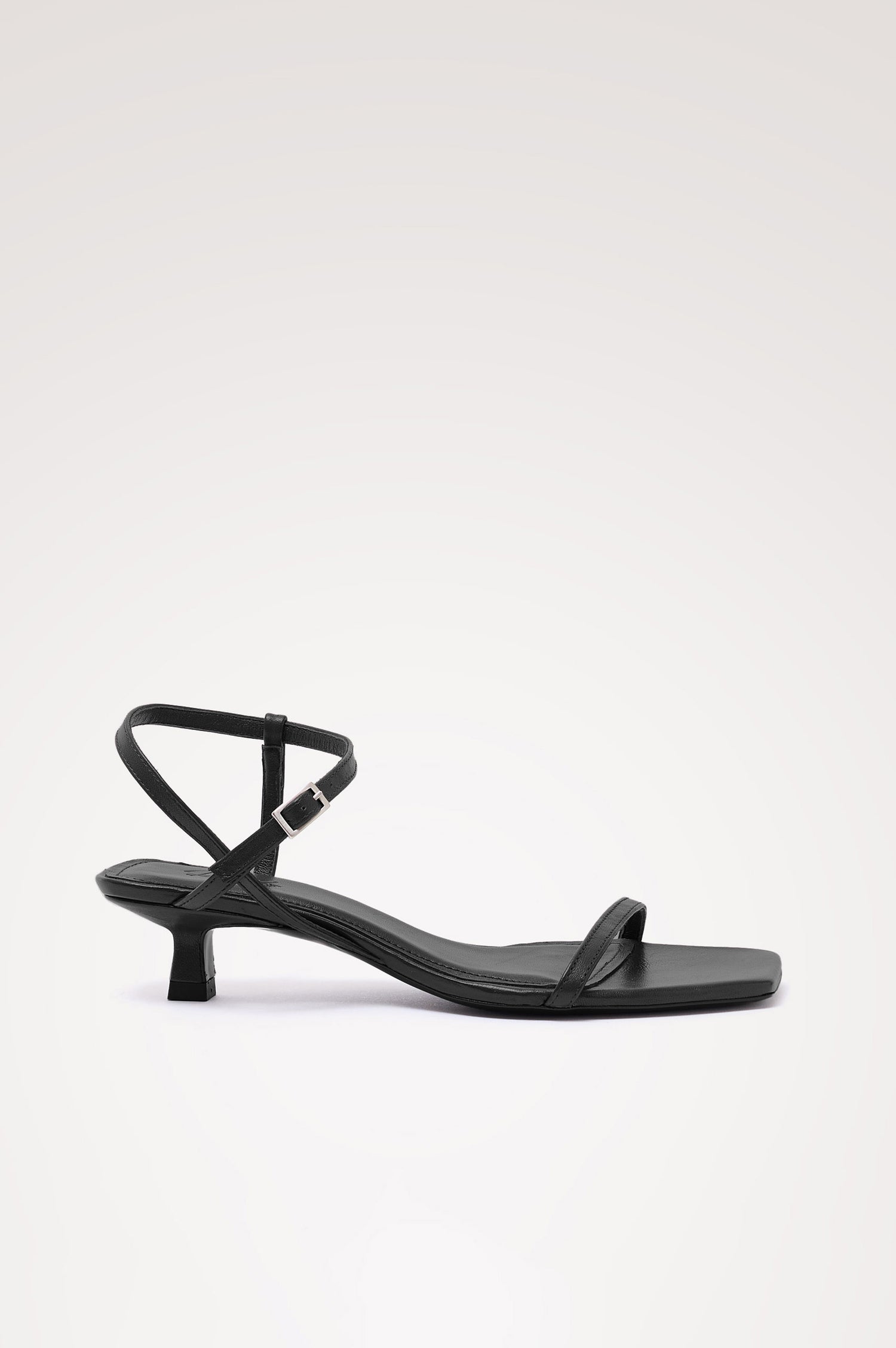 Palma Sandal Heel in Top-Grain Leather With Single Toe Strap, Adjustable Buckled Wrap Ankle Strap, and Low Heel in Black Colorway - side view of shoe.