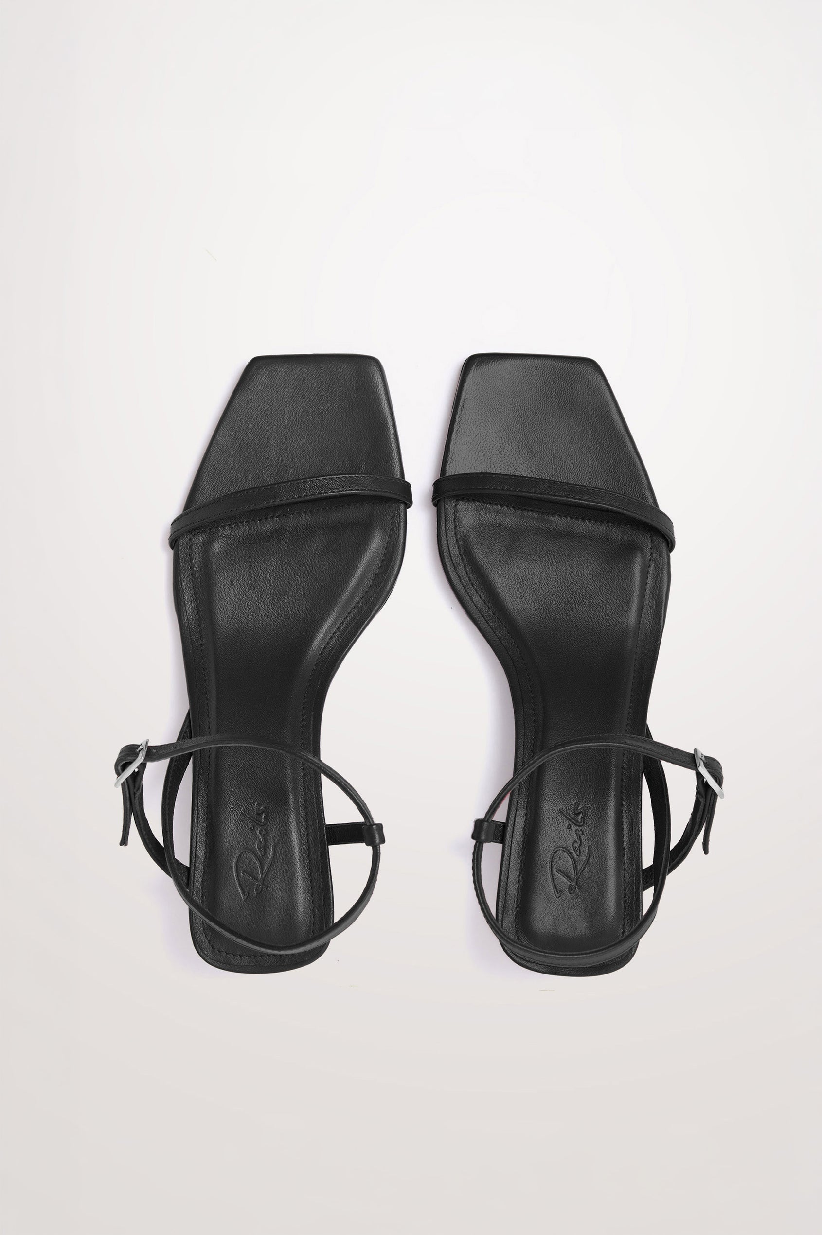 Palma Sandal Heel in Top-Grain Leather With Single Toe Strap, Adjustable Buckled Wrap Ankle Strap, and Low Heel in Black Colorway - top view of shoe.